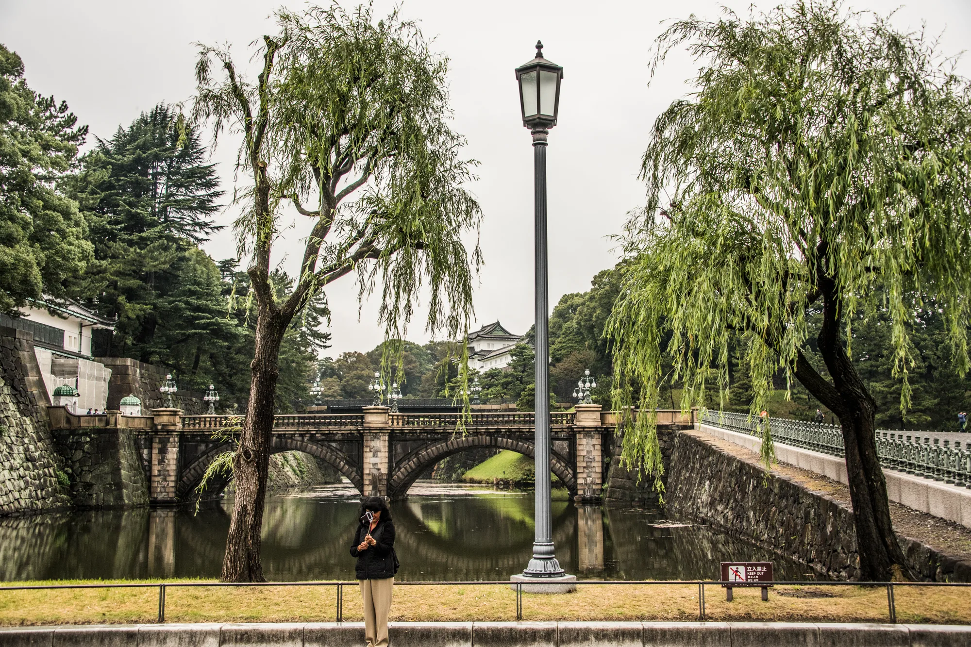 Woman taking a selfie before Nijubashi bridge and the Imperial Palace, Tokyo — Japan, travel and street photography by Janina Laszlo