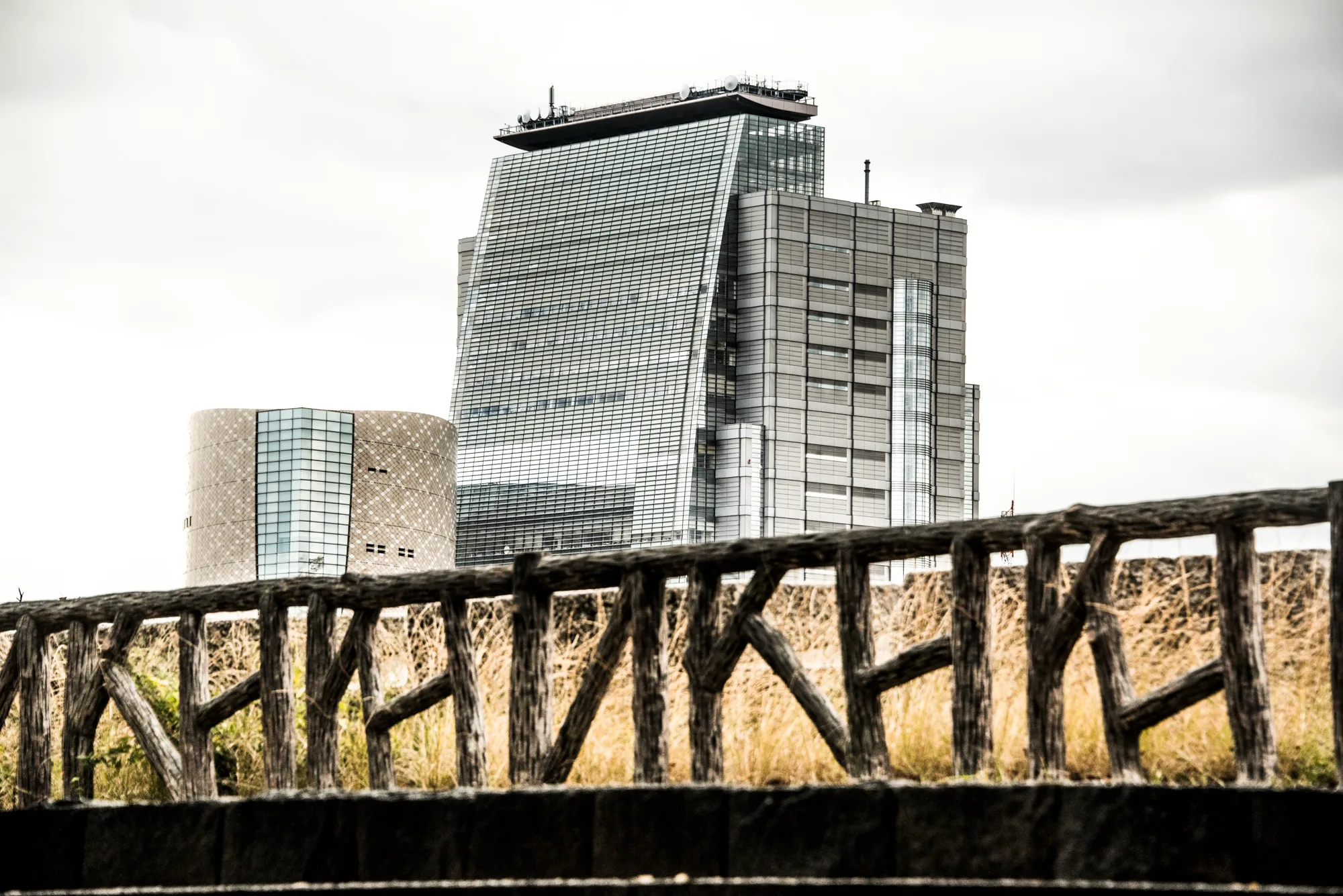 Modern office tower and museum behind a rustic wooden fence, Osaka — Japan, travel and street photography by Janina Laszlo