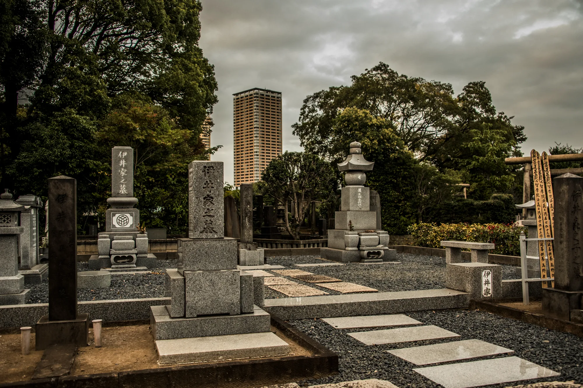 Family graves with stone lanterns and a high-rise behind, Japan — Japan, travel and street photography by Janina Laszlo