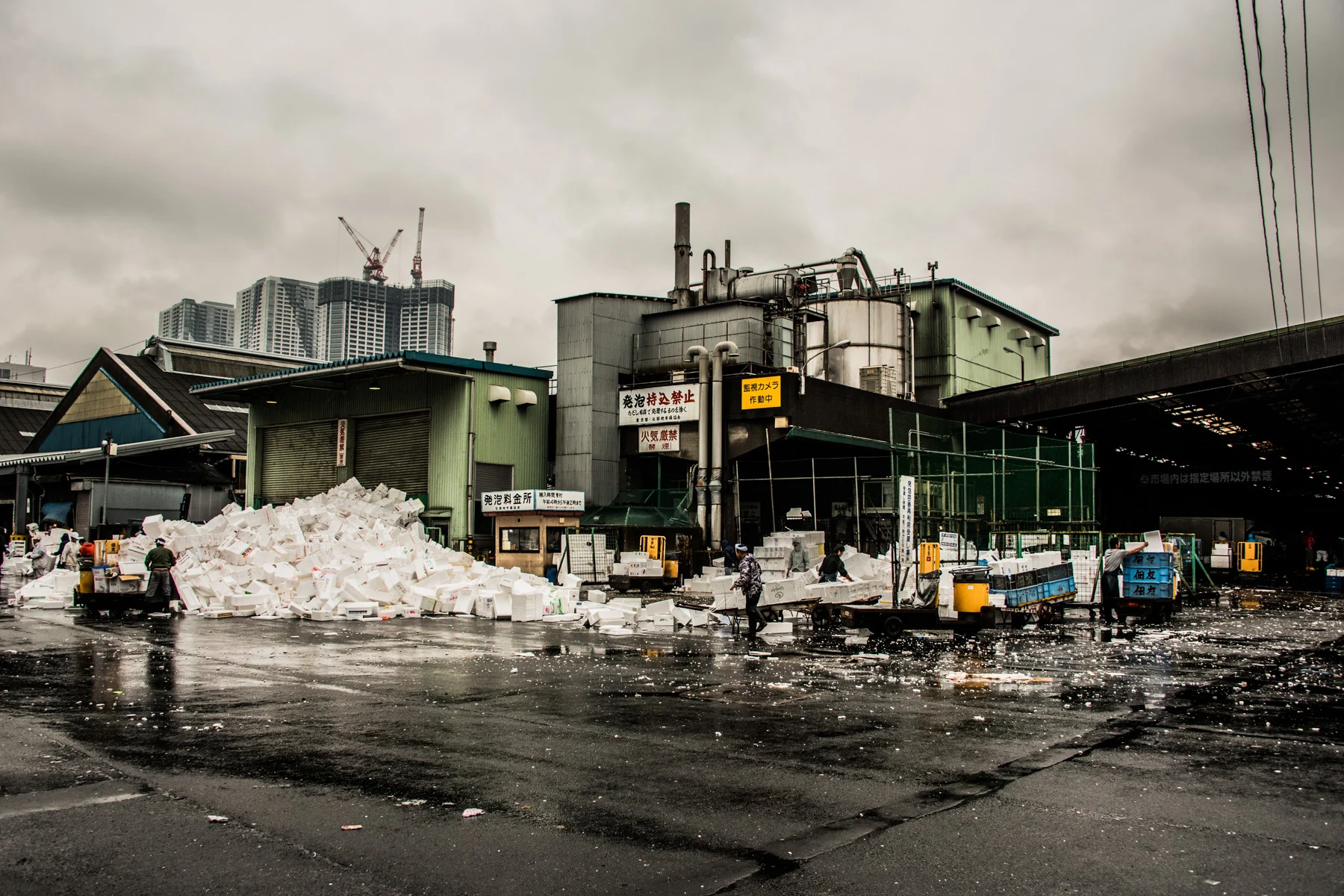 Workers clearing a mountain of white styrofoam boxes on the wet grounds of Tsukiji fish market, Tokyo — Japan, travel and street photography by Janina Laszlo