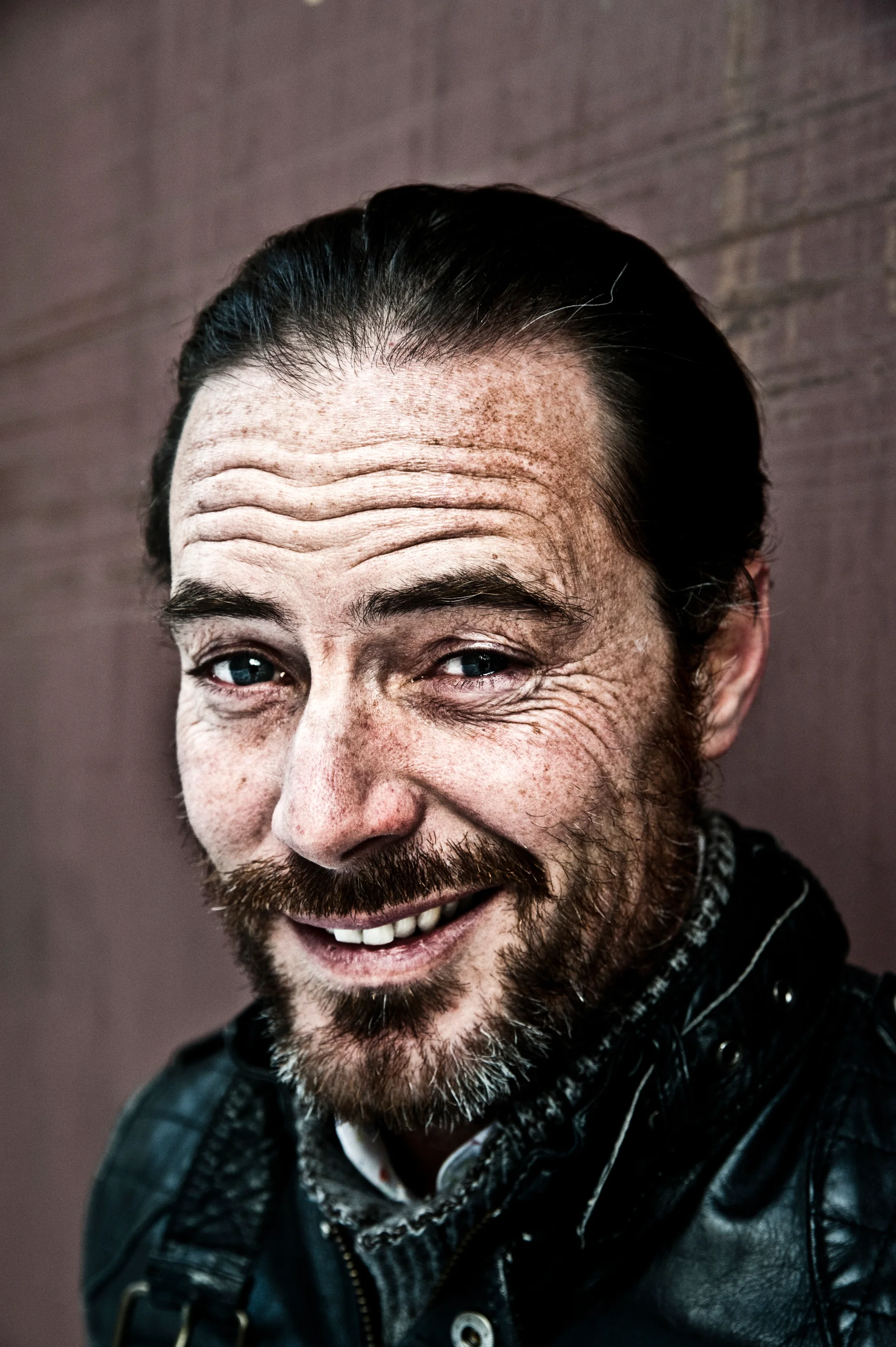 John Friedmann laughing, close-up against a dark background — John Friedmann, actor portrait photography by Janina Laszlo