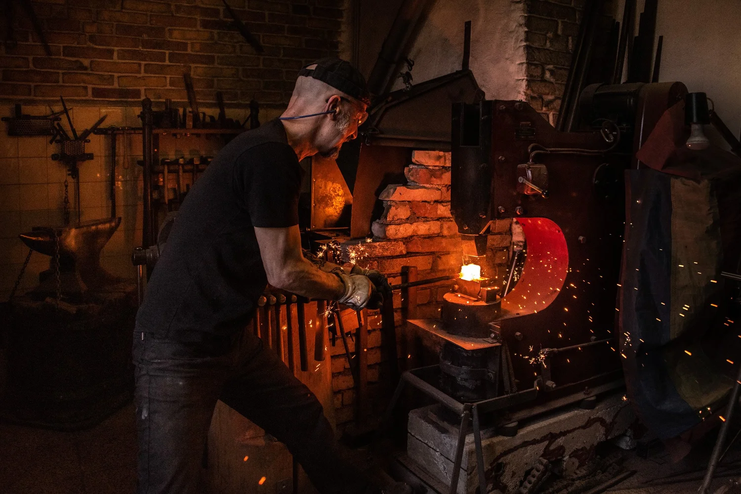 Knife smith Alfons Bolley at the glowing forge in his dark smithy — reportage by Janina Laszlo, photographer in Munich