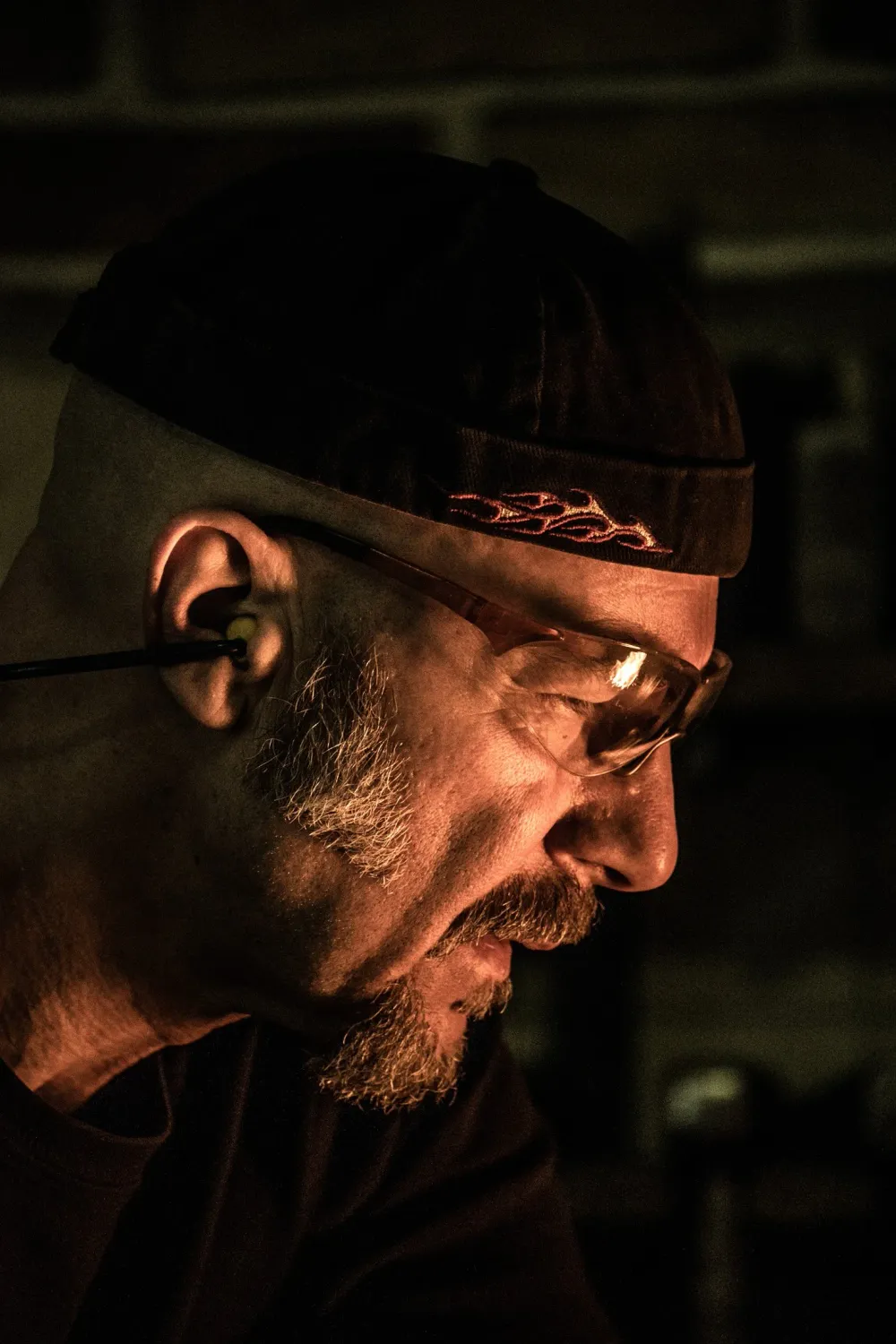 Profile of knife smith Alfons Bolley with safety glasses in the dark smithy — knife smith Alfons Bolley — reportage by Janina Laszlo, photographer in Munich