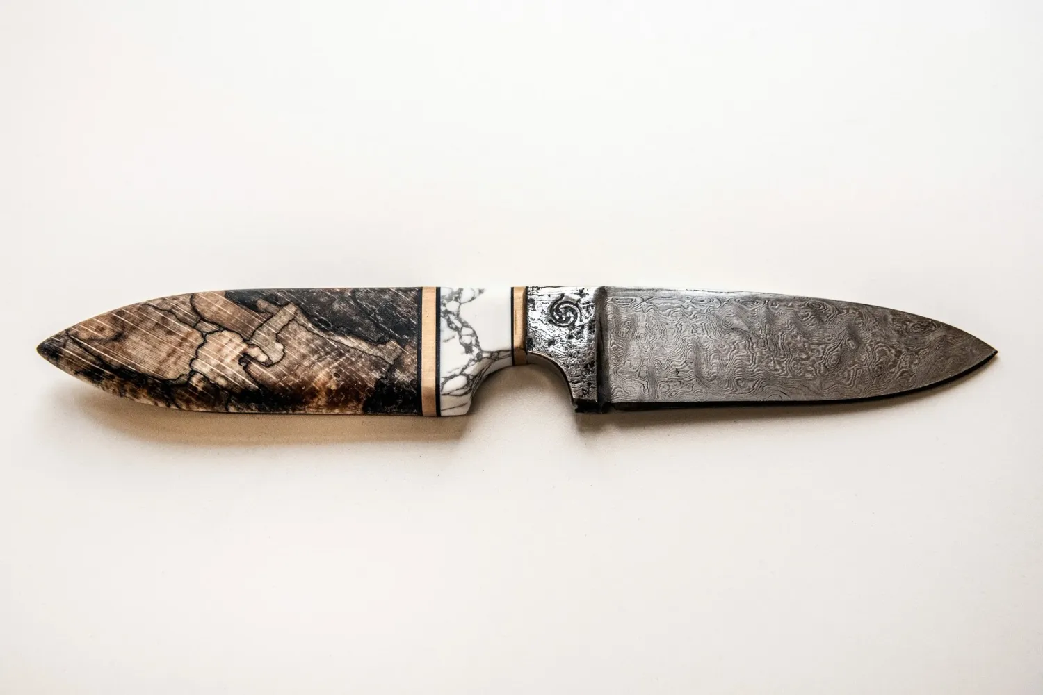 Finished hand-forged knife with patterned blade on white — knife smith Alfons Bolley — reportage by Janina Laszlo, photographer in Munich