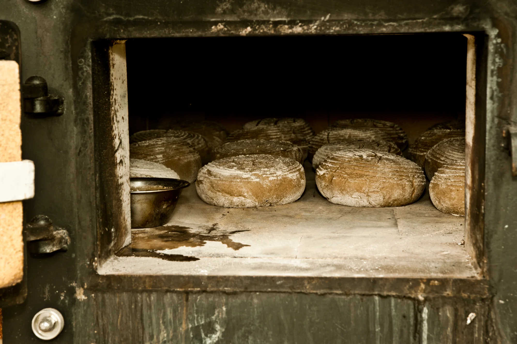 Round rye loaves baking in the open stone hearth of a wood-fired oven — Landbäckerei Zobel, Seefeld, Bavaria, craft bakery photography by Janina Laszlo