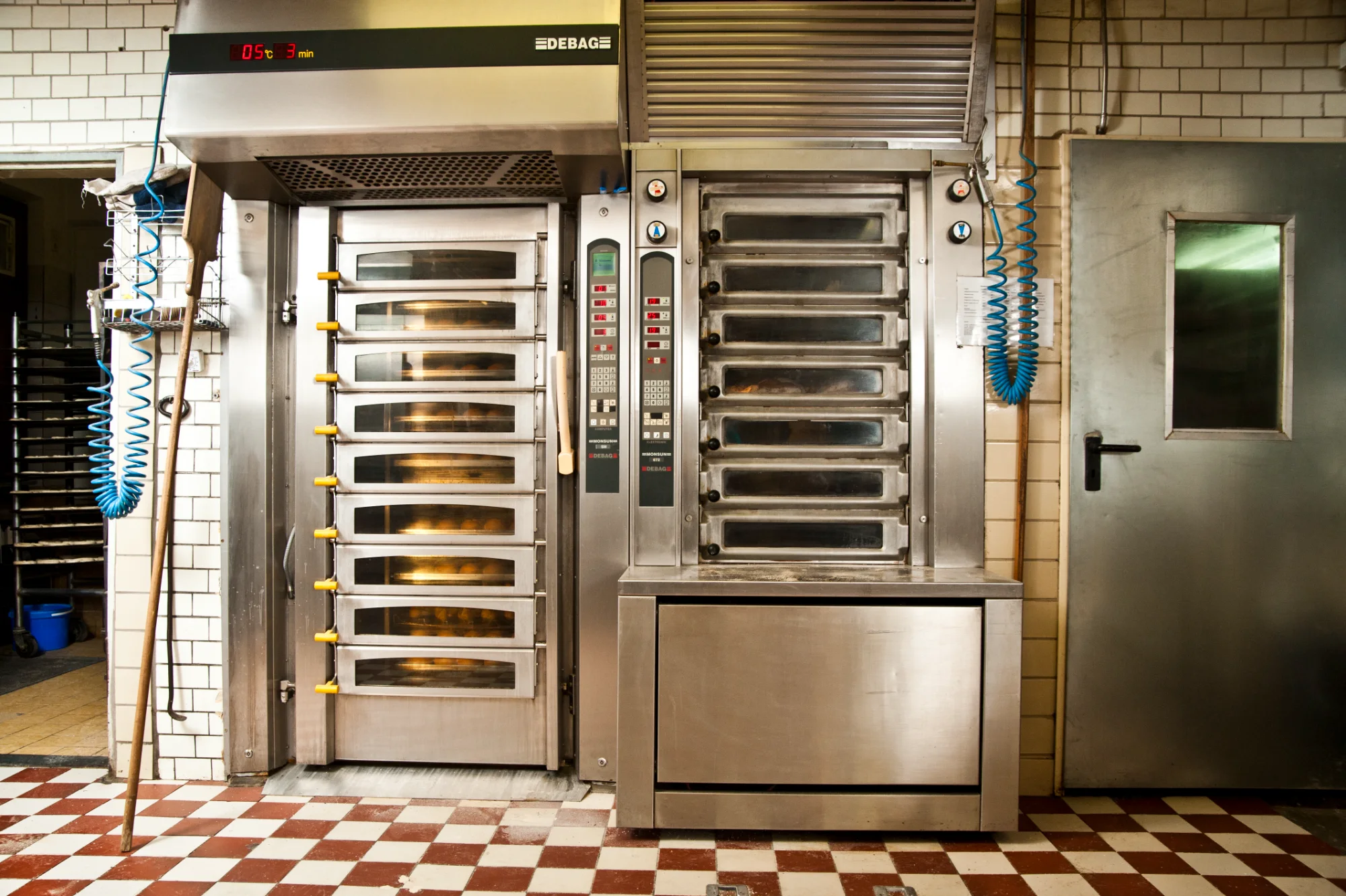 Stainless steel deck ovens with rolls baking behind glass doors — Landbäckerei Zobel, Seefeld, Bavaria, craft bakery photography by Janina Laszlo