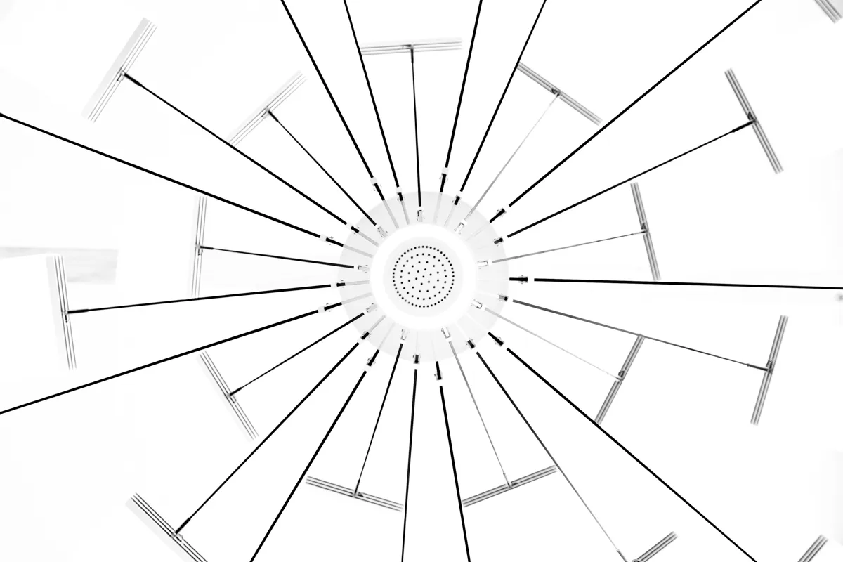 Radial view up into the LC 1.0 chandelier: black rods spreading from the white centre — LC 1.0 chandelier by Denise M. Hachinger, product and design photography by Janina Laszlo