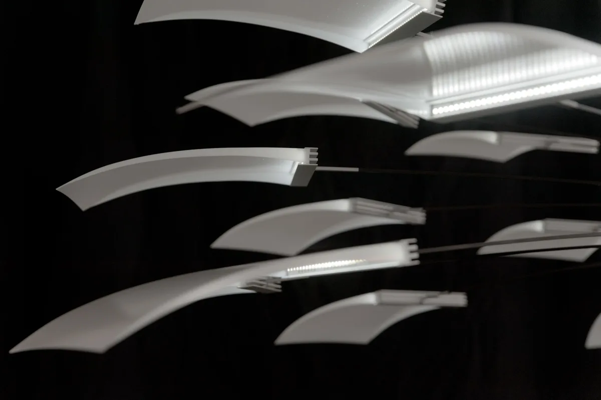 Curved light panels of the LC 1.0 chandelier with LED edges, side view against black — LC 1.0 chandelier by Denise M. Hachinger, product and design photography by Janina Laszlo
