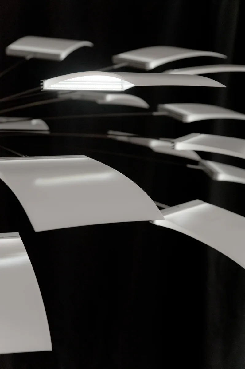 Layers of curved panels of the LC 1.0 chandelier, one LED edge glowing — LC 1.0 chandelier by Denise M. Hachinger, product and design photography by Janina Laszlo