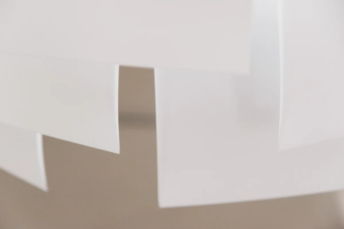 White sheets of the LC 1.0 chandelier against a warm grey background, minimal detail — LC 1.0 chandelier by Denise M. Hachinger, product and design photography by Janina Laszlo