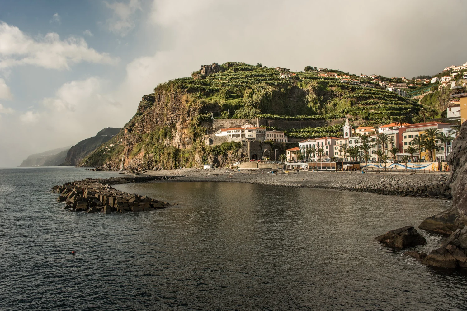 Ponta do Sol with its church tower, palm-lined promenade and banana terraces above a pebble beach, Madeira — Madeira, travel and landscape photography by Janina Laszlo