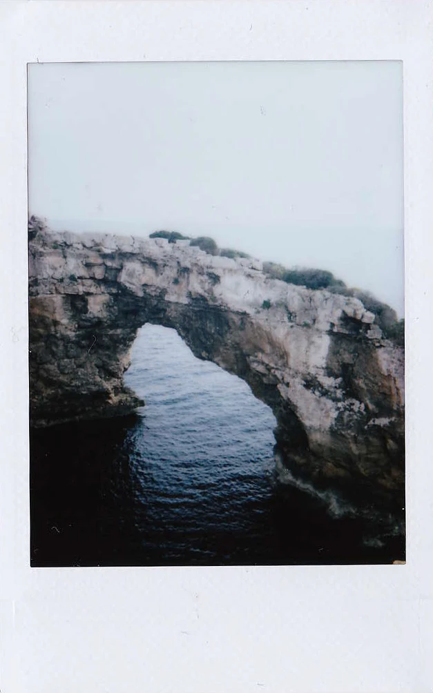 Polaroid of a natural rock arch over the sea on the limestone coast, Mallorca — Mallorca Polaroids, analog travel photography by Janina Laszlo