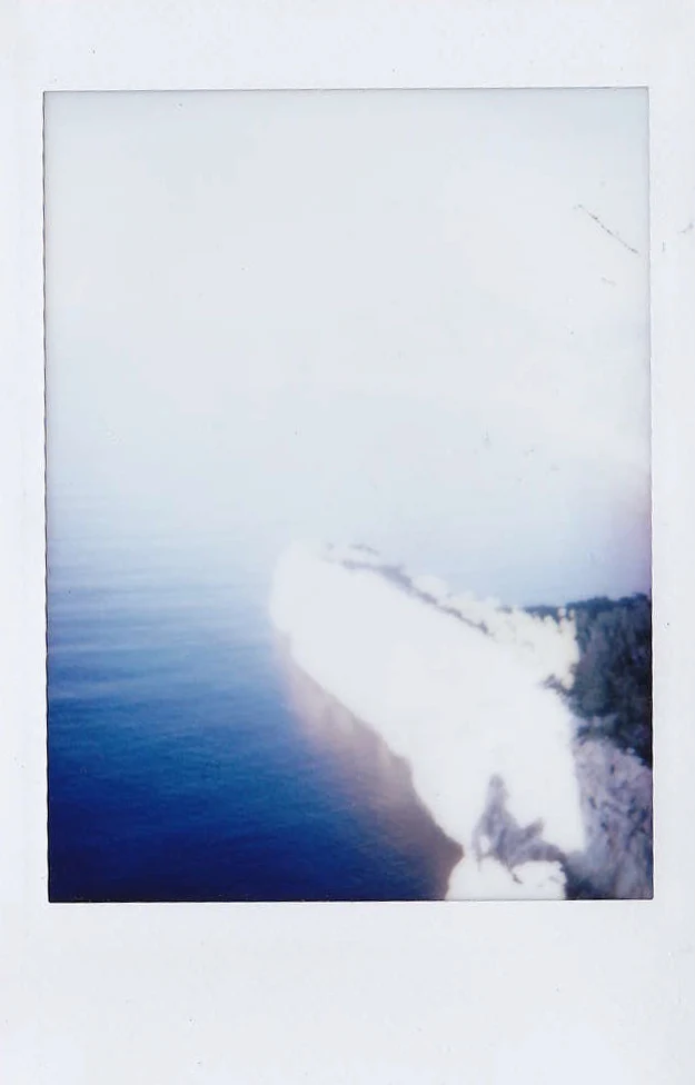Polaroid of a pale limestone cliff dropping into the deep blue Mediterranean, seen from above, Mallorca — Mallorca Polaroids, analog travel photography by Janina Laszlo