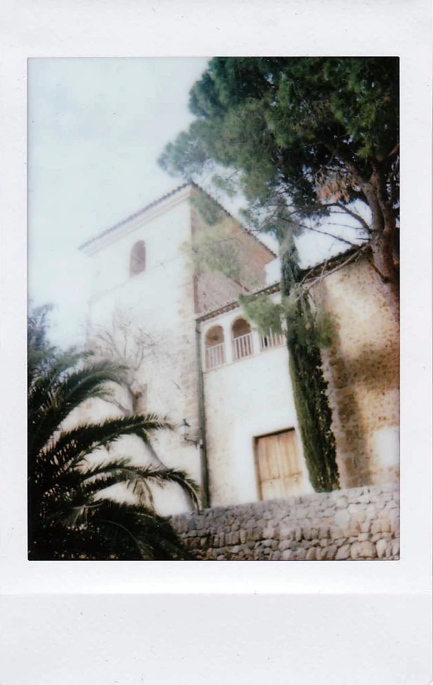 Polaroid of a stone manor house with arched loggia, pines and palms, Mallorca — Mallorca Polaroids, analog travel photography by Janina Laszlo