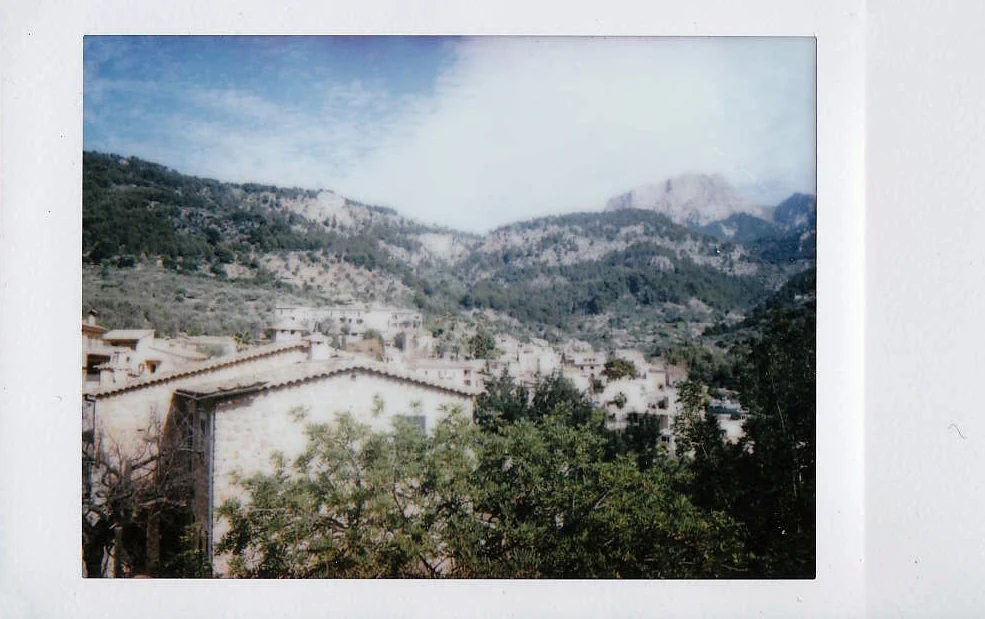 Polaroid of a mountain village with stone houses in a green valley, Serra de Tramuntana, Mallorca — Mallorca Polaroids, analog travel photography by Janina Laszlo