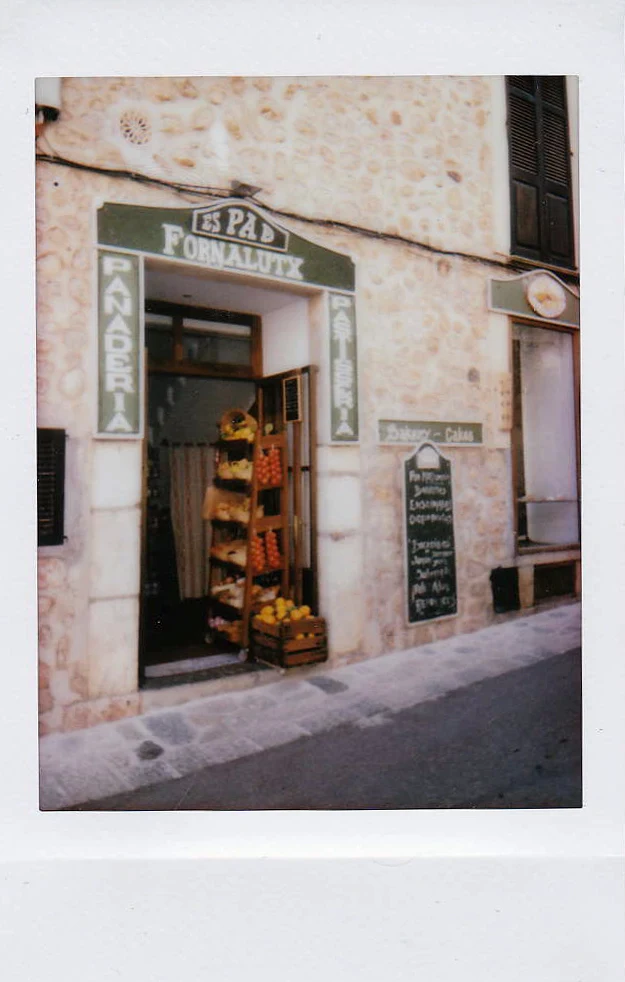 Polaroid of a village shop doorway with fruit crates and a painted sign, Mallorca — Mallorca Polaroids, analog travel photography by Janina Laszlo