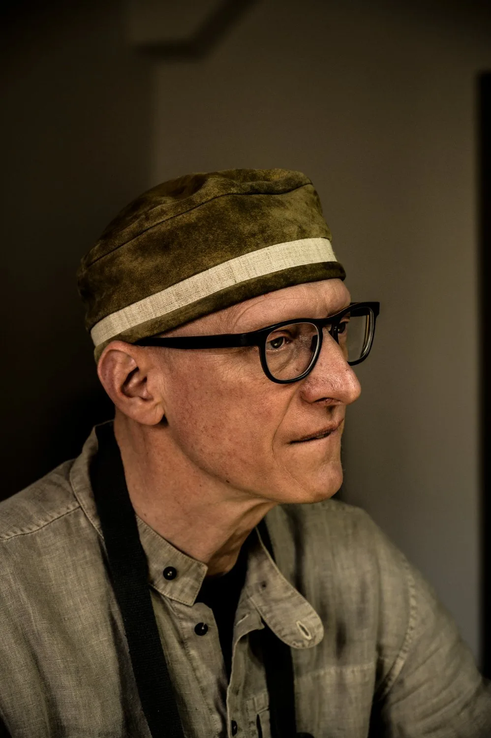 Portrait of Martin Schleske in cap and glasses, looking to the side — Martin Schleske, master violin maker, editorial portrait and documentary photography by Janina Laszlo, Landsberg am Lech