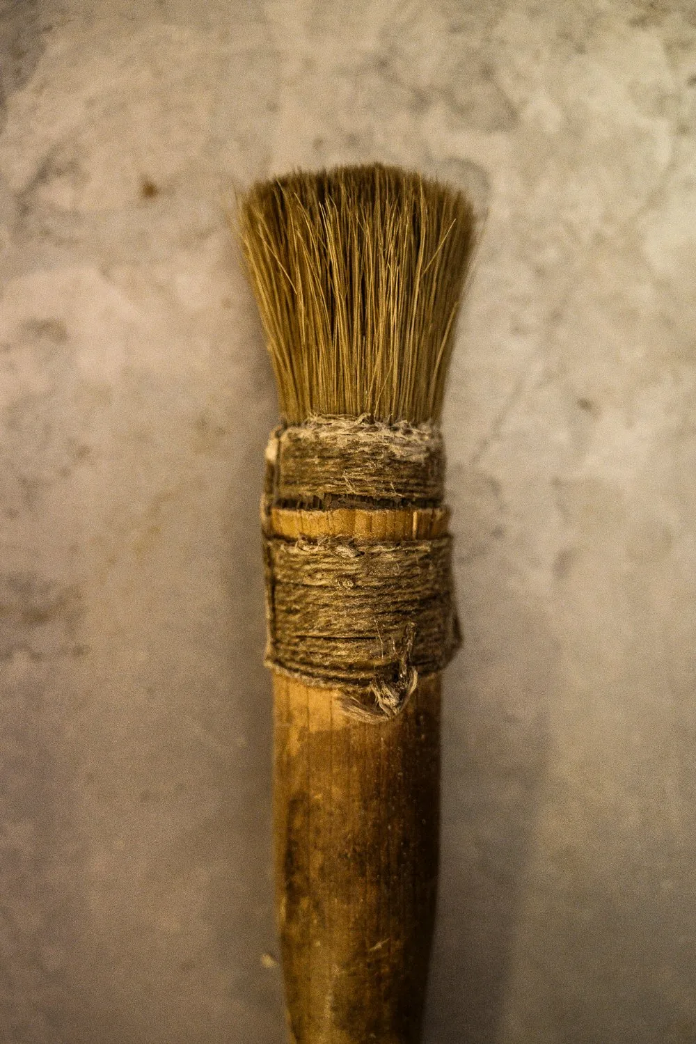 Worn glue brush on a stone surface — Martin Schleske, master violin maker, editorial portrait and documentary photography by Janina Laszlo, Landsberg am Lech