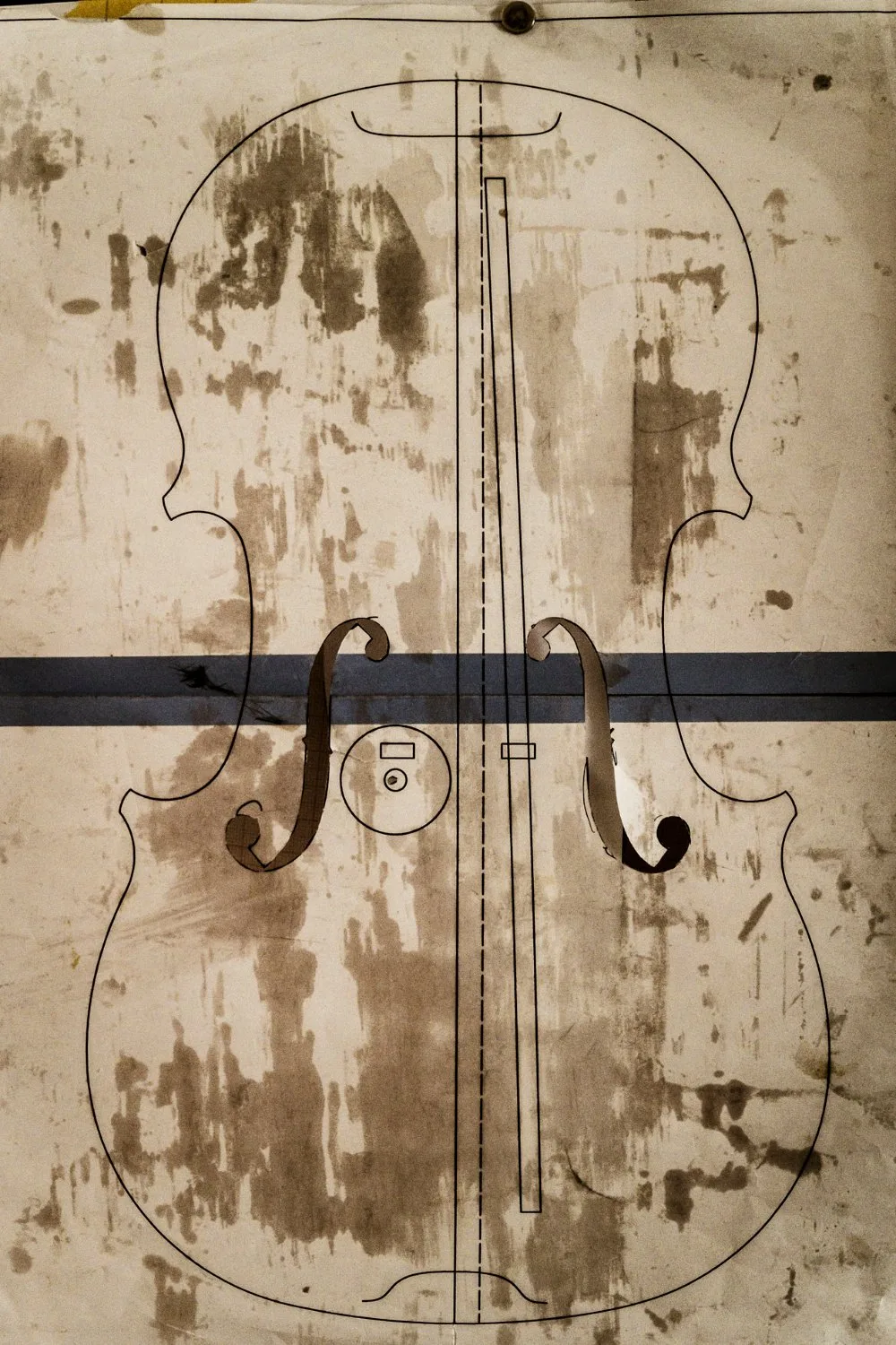 Violin outline drawn on a worn workshop template — Martin Schleske, master violin maker, editorial portrait and documentary photography by Janina Laszlo, Landsberg am Lech