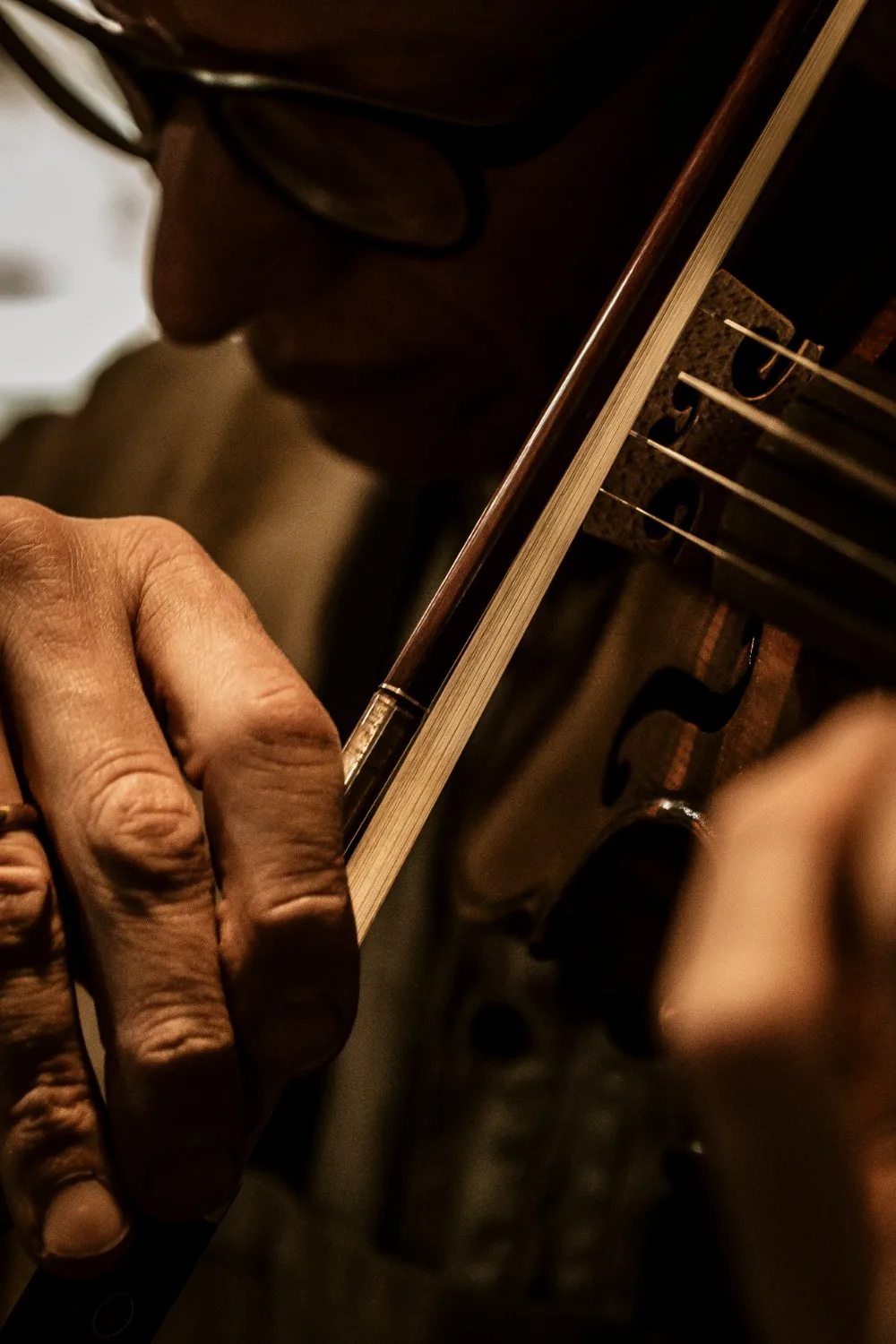 Detail of bow and strings while playing a violin — Martin Schleske, master violin maker, editorial portrait and documentary photography by Janina Laszlo, Landsberg am Lech