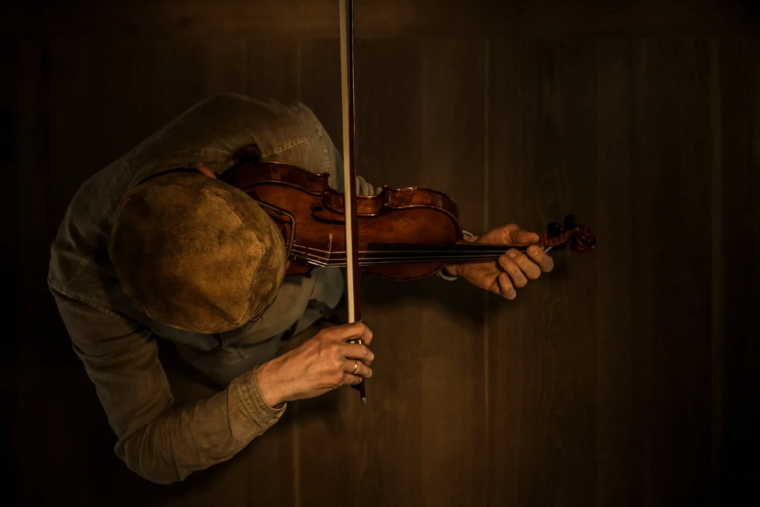 Top-down view of Martin Schleske playing violin — Martin Schleske, master violin maker, editorial portrait and documentary photography by Janina Laszlo, Landsberg am Lech