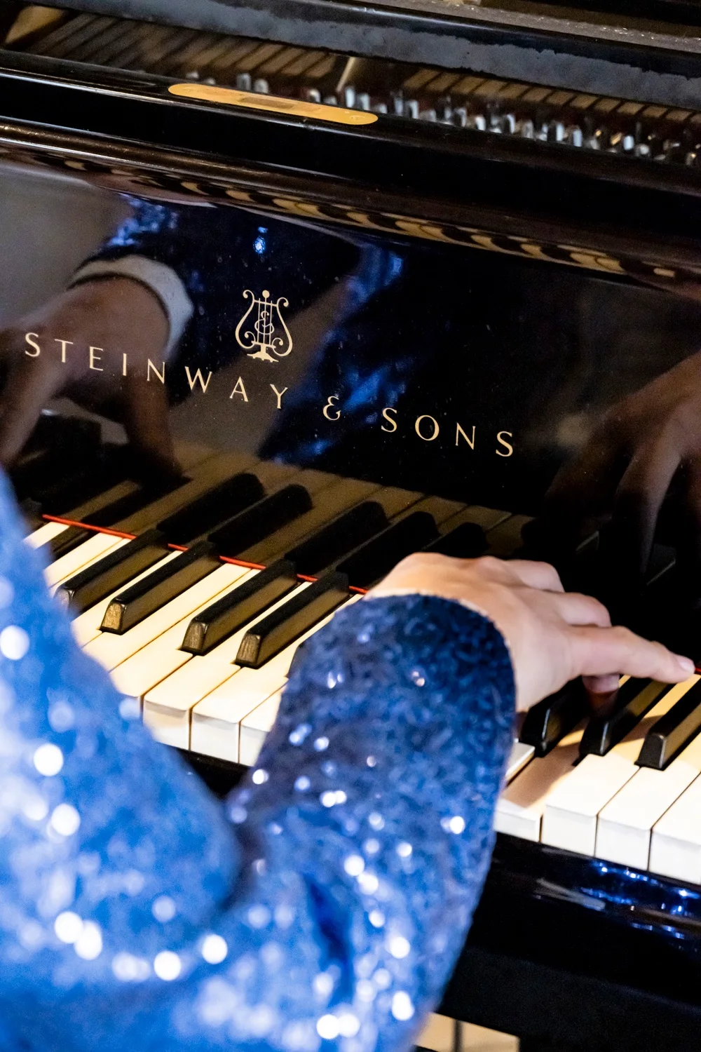 Hands in a blue sequin sleeve on the keys of a Steinway grand piano — Matthias Heiligensetzer, pianist & entertainer, musician portrait photography by Janina Laszlo, Munich