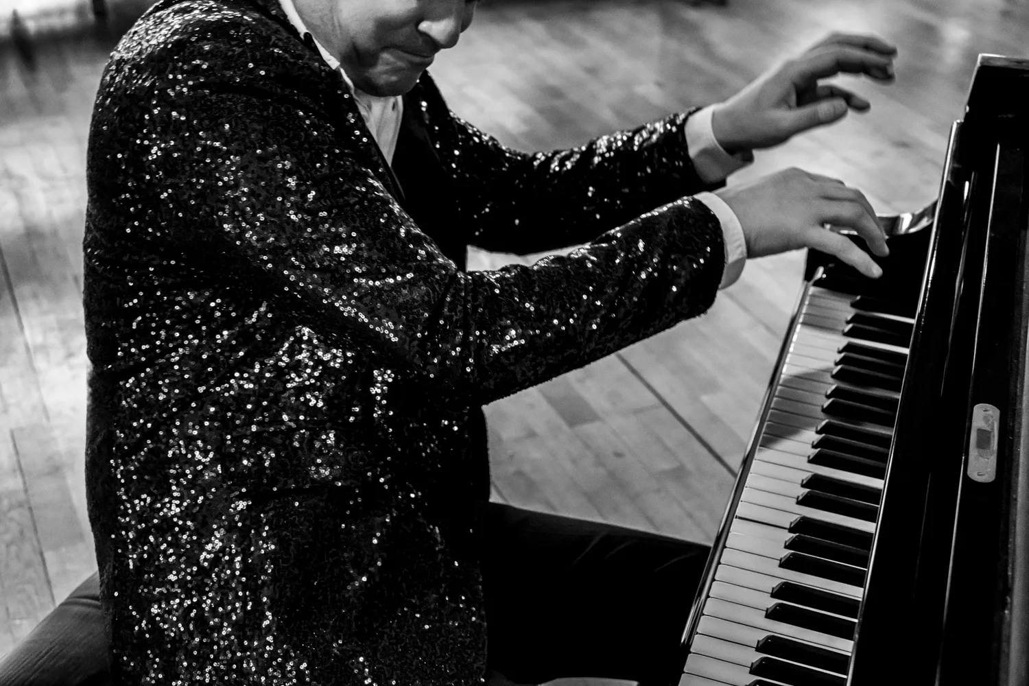 Matthias Heiligensetzer in a sequin jacket playing an upright piano, black-and-white — Matthias Heiligensetzer, pianist & entertainer, musician portrait photography by Janina Laszlo, Munich