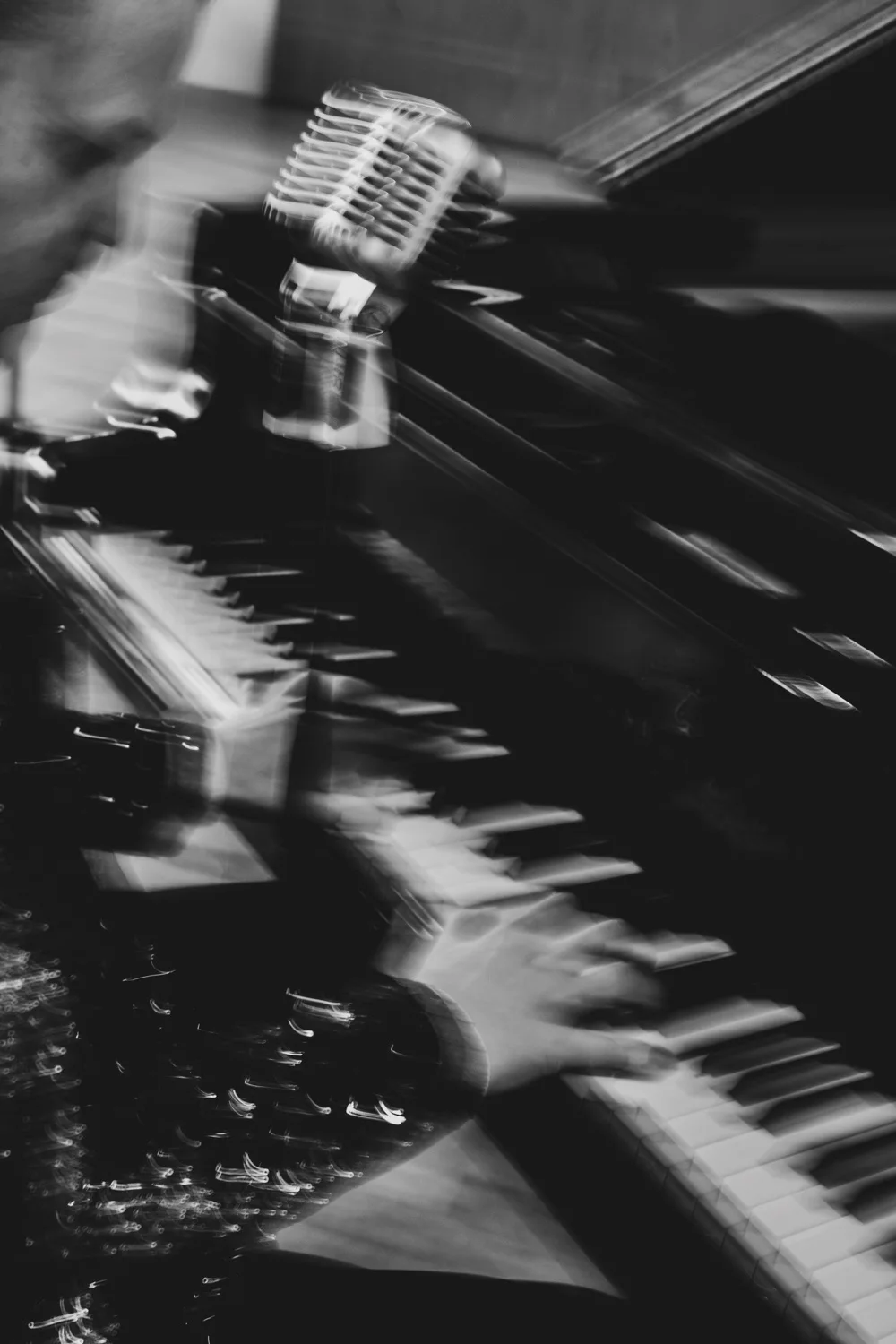 Motion-blurred hands, microphone and piano keys in a long exposure, black-and-white — Matthias Heiligensetzer, pianist & entertainer, musician portrait photography by Janina Laszlo, Munich