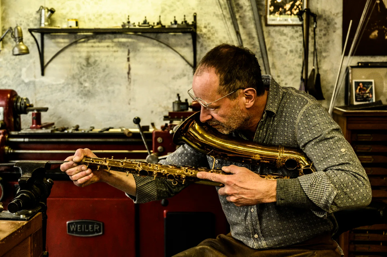 Max Frei aligning the body of a saxophone at the vice — Max Frei, saxophone workshop in Icking near Munich, corporate portraits and editorial photography by Janina Laszlo