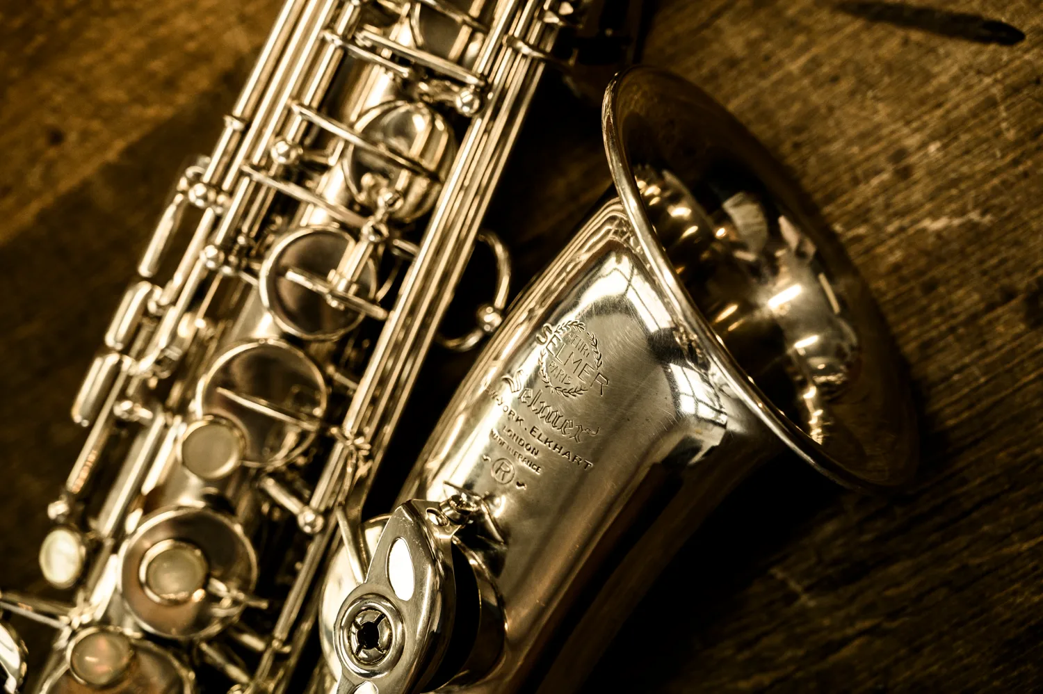 Engraving of a Selmer saxophone bell on a wooden table — Max Frei, saxophone workshop in Icking near Munich, corporate portraits and editorial photography by Janina Laszlo