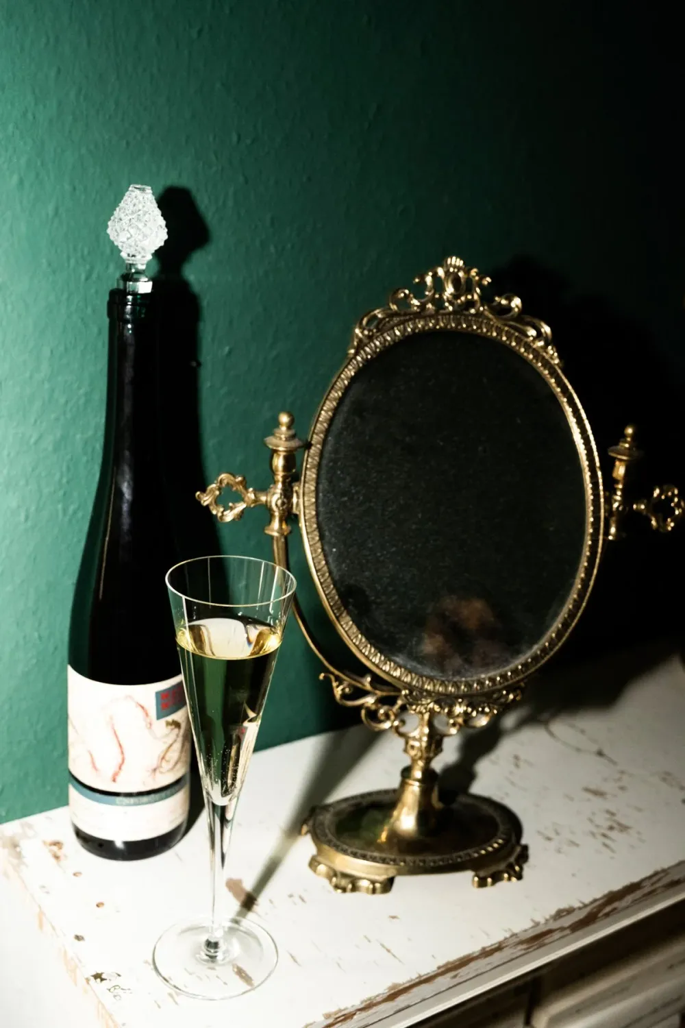 Still life with a champagne bottle and gilded mirror on a mantelpiece, Na'ama Goldman series — portrait by Janina Laszlo, portrait photographer in Munich