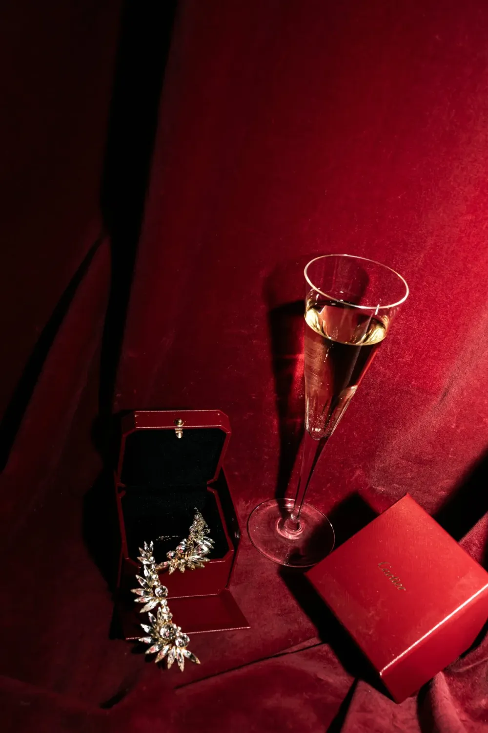Champagne glass and red gift box on red velvet, still life, Na'ama Goldman series — portrait by Janina Laszlo, portrait photographer in Munich