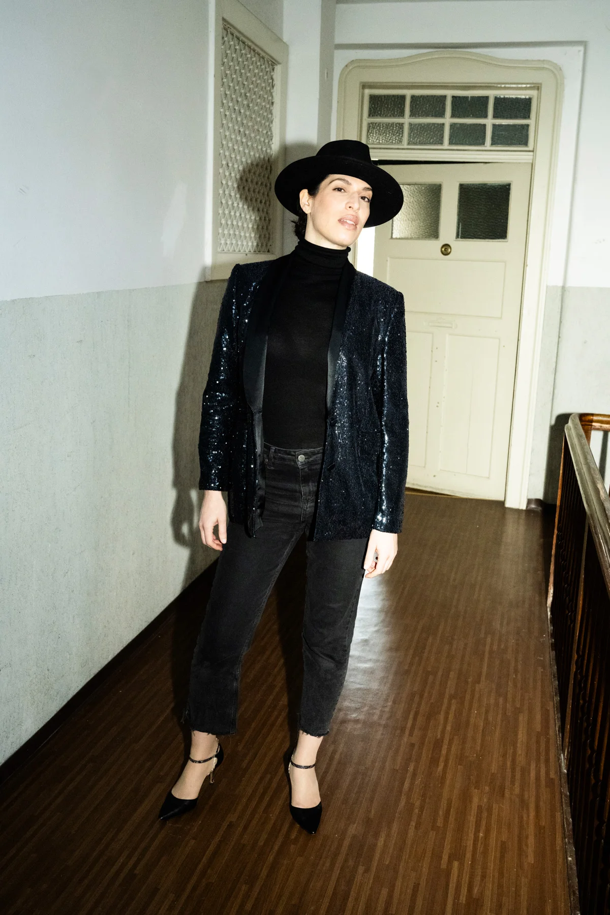 Na’ama Goldman in black with a hat in a hallway — Na’ama Goldman, mezzo-soprano, opera portrait photography by Janina Laszlo