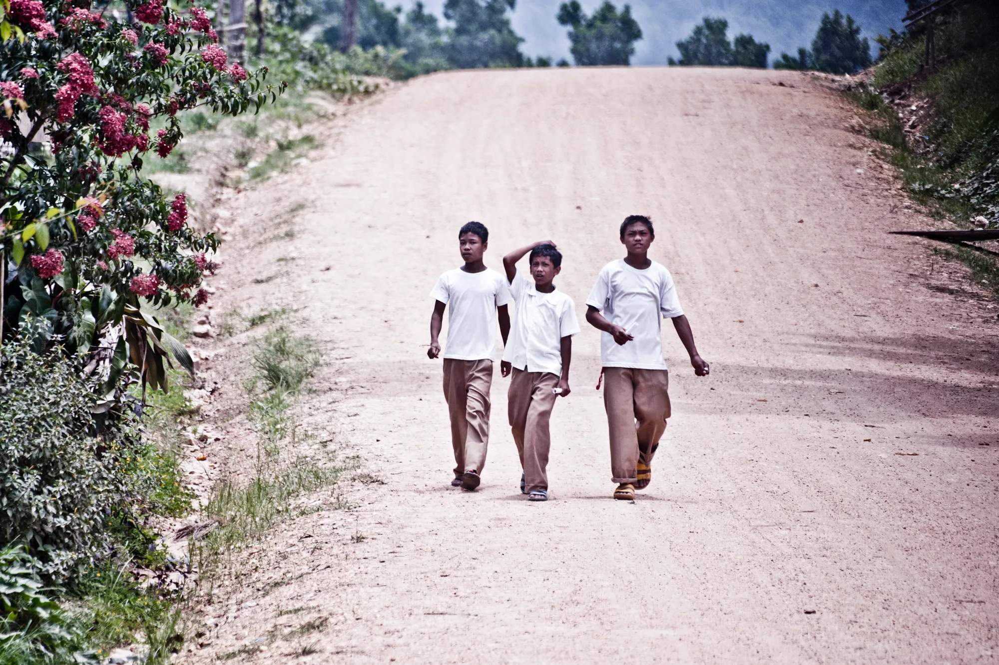 Three schoolboys in uniform walking down a dirt road — Palawan, Philippines, documentary and travel photography by Janina Laszlo