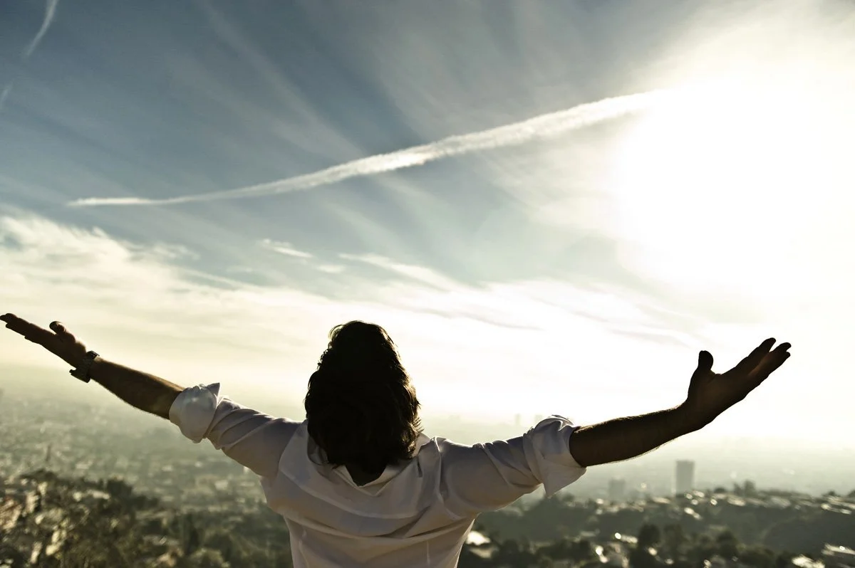 Actor Christian Oliver with arms spread wide against a dramatic sky over Los Angeles — portrait by Janina Laszlo, portrait photographer in Munich