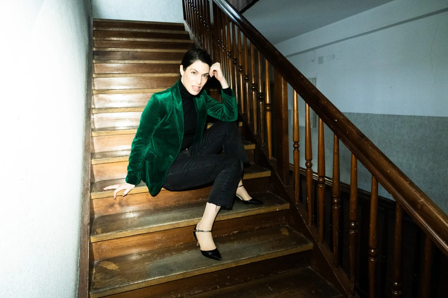Mezzo-soprano Na'ama Goldman in a green velvet coat on an old wooden staircase — portrait by Janina Laszlo, portrait photographer in Munich