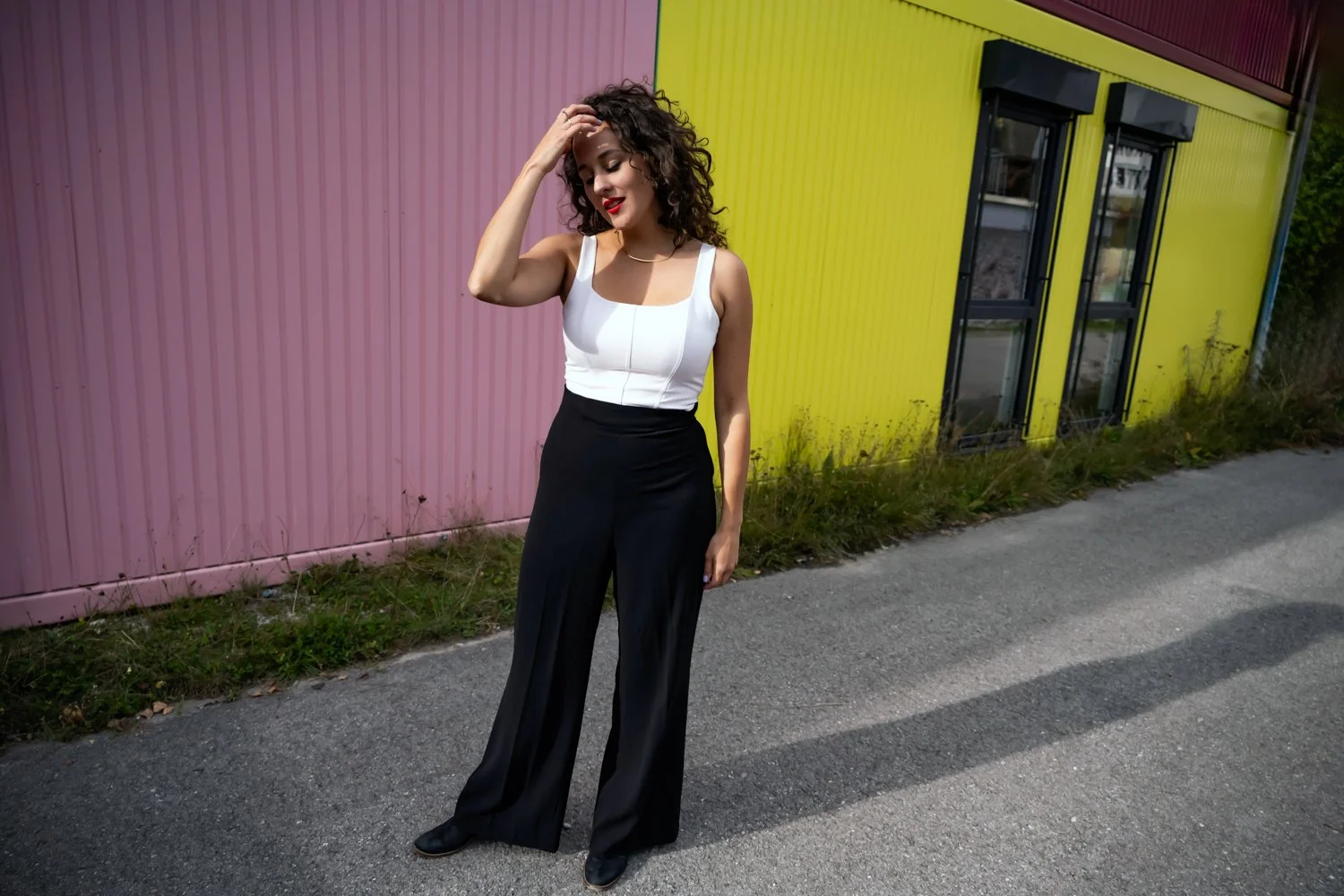 Mezzo-soprano Marie Seidler in front of a bright pink and yellow wall — portrait by Janina Laszlo, portrait photographer in Munich