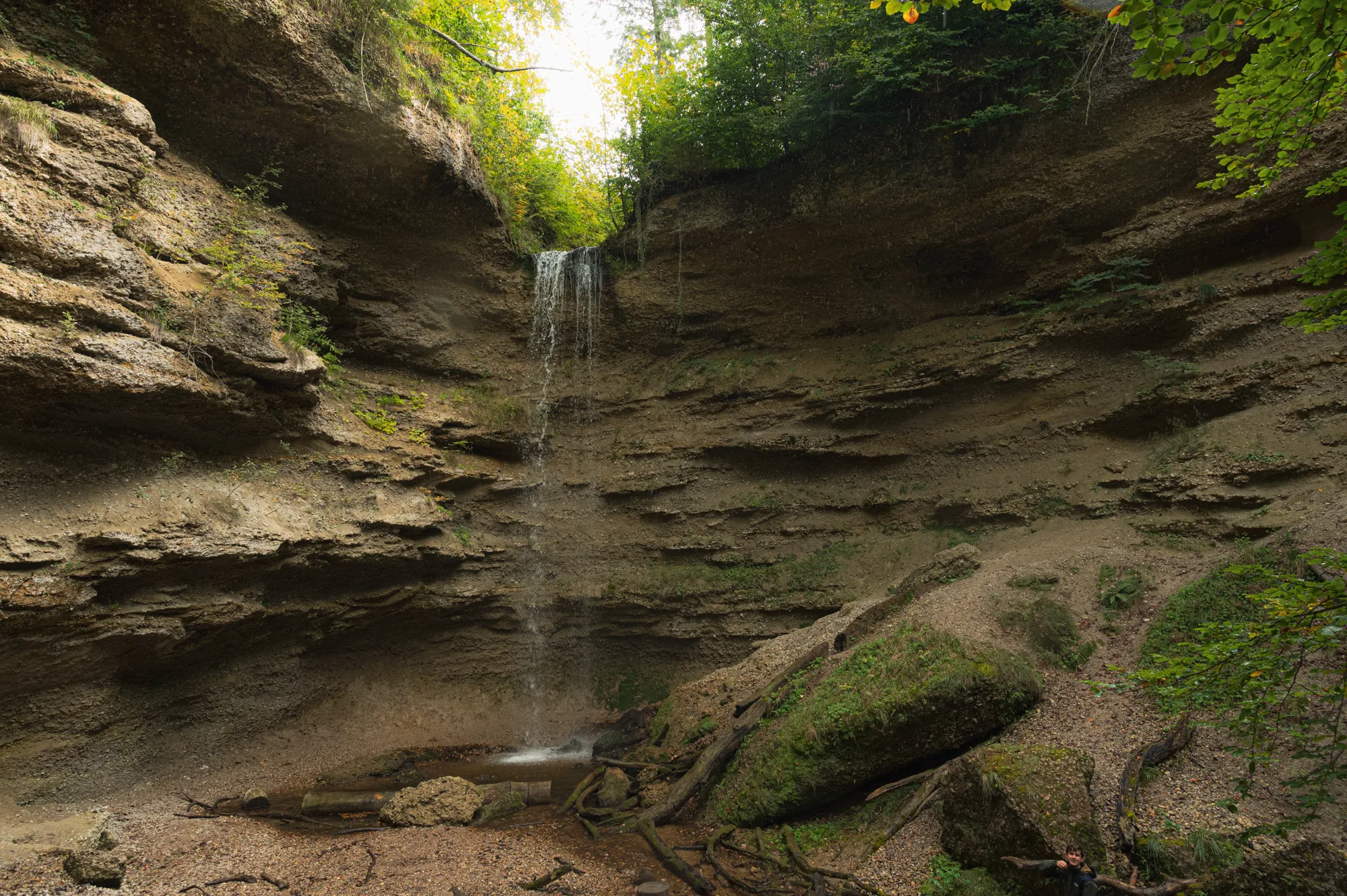 Waterfall dropping over layered sandstone cliffs into a shaded gorge in the Pähler Schlucht gorge near Pähl — Fünfseenland for SEEMAGAZIN, editorial travel and landscape photography by Janina Laszlo, Munich