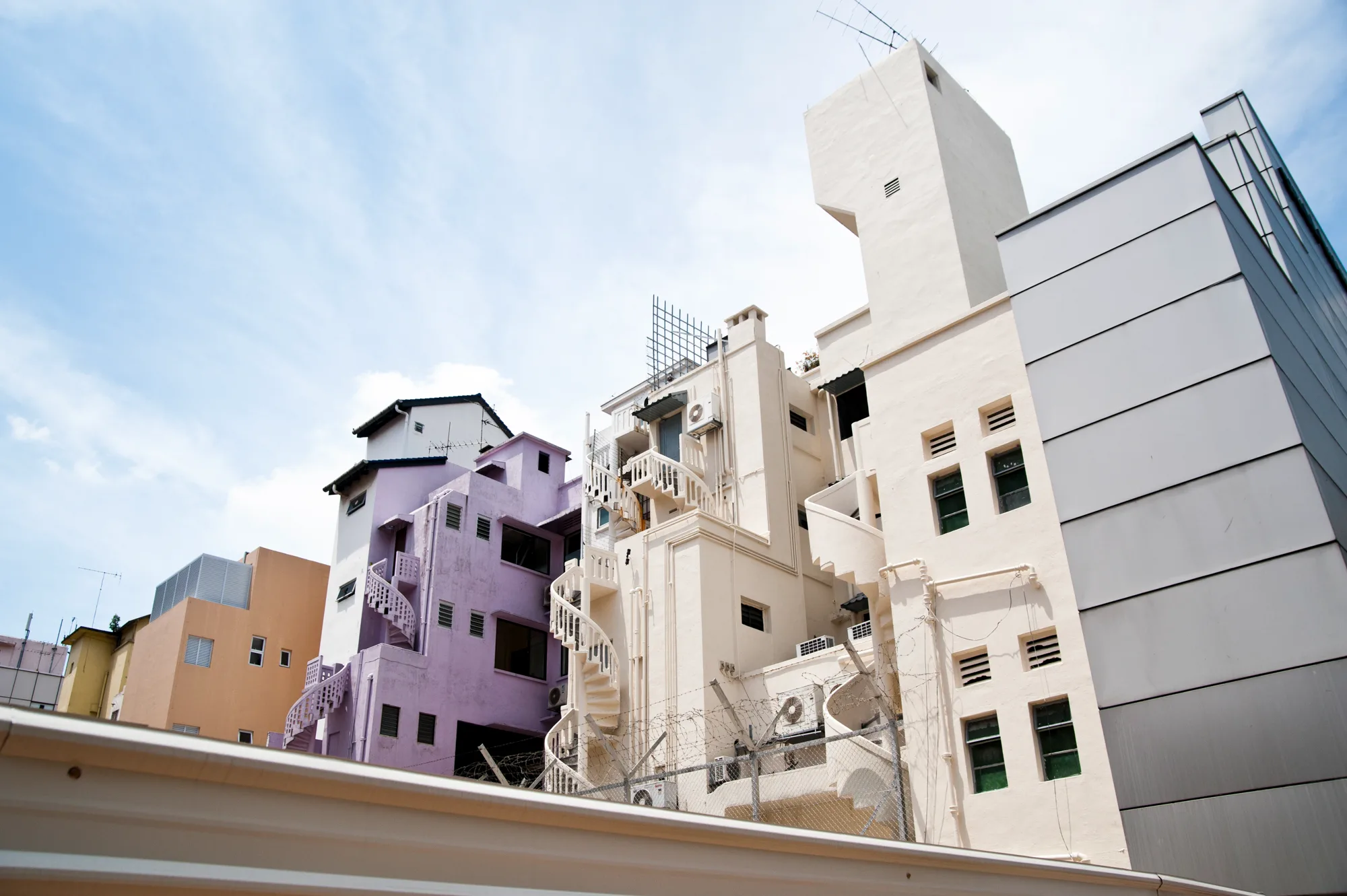 Spiral staircases on the backs of pastel shophouses — Singapore, architecture and travel photography by Janina Laszlo