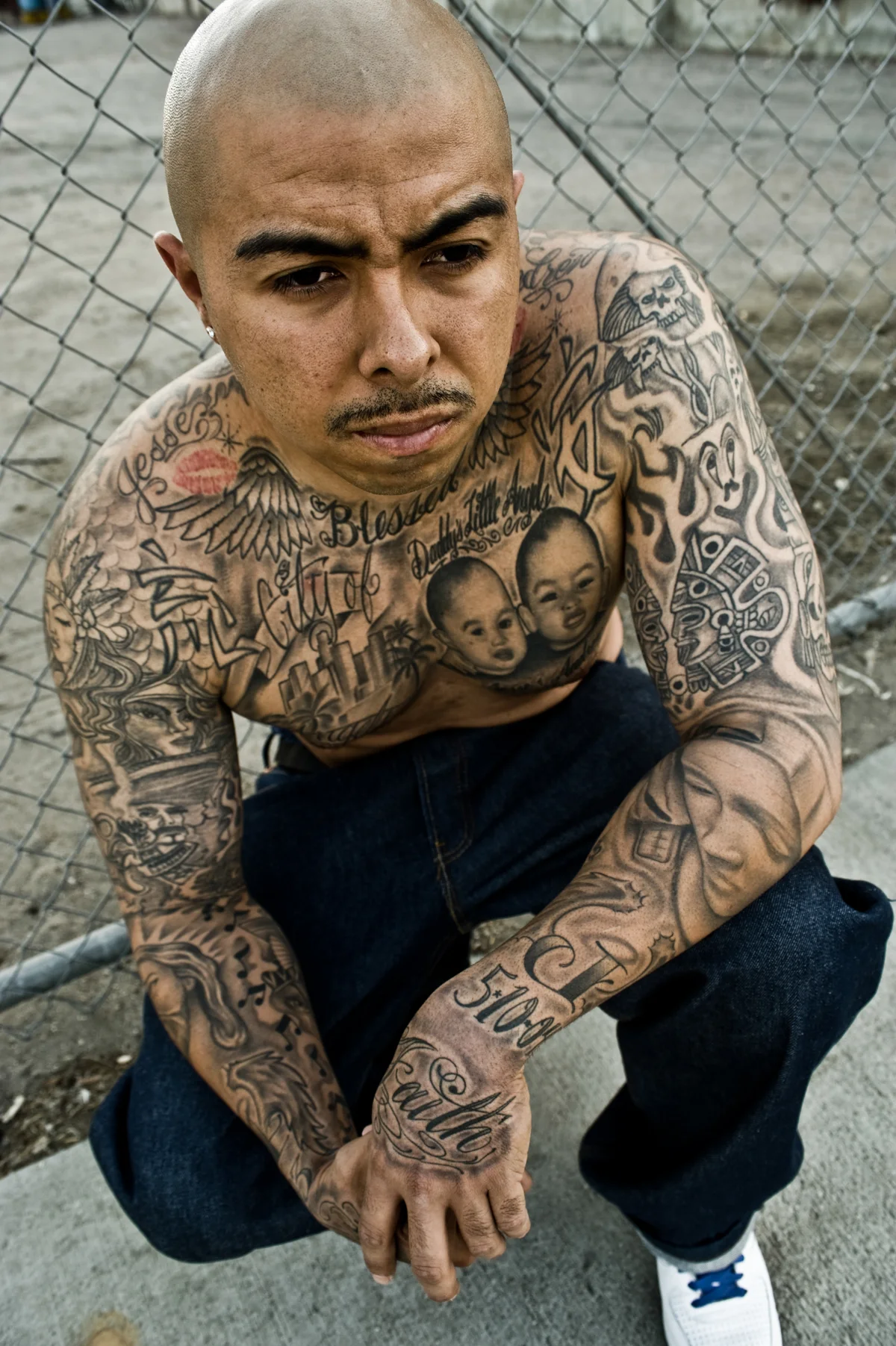 Tattooed artist crouching on the pavement in East Los Angeles — Suspect Entertainment, music portrait photography by Janina Laszlo