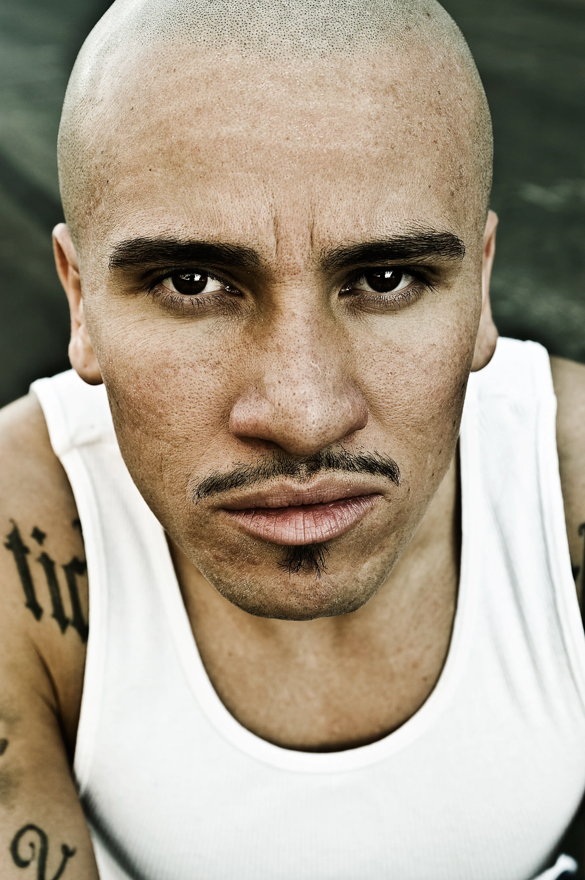 Close-up of a bald artist in a white tank top in East Los Angeles — Suspect Entertainment, music portrait photography by Janina Laszlo