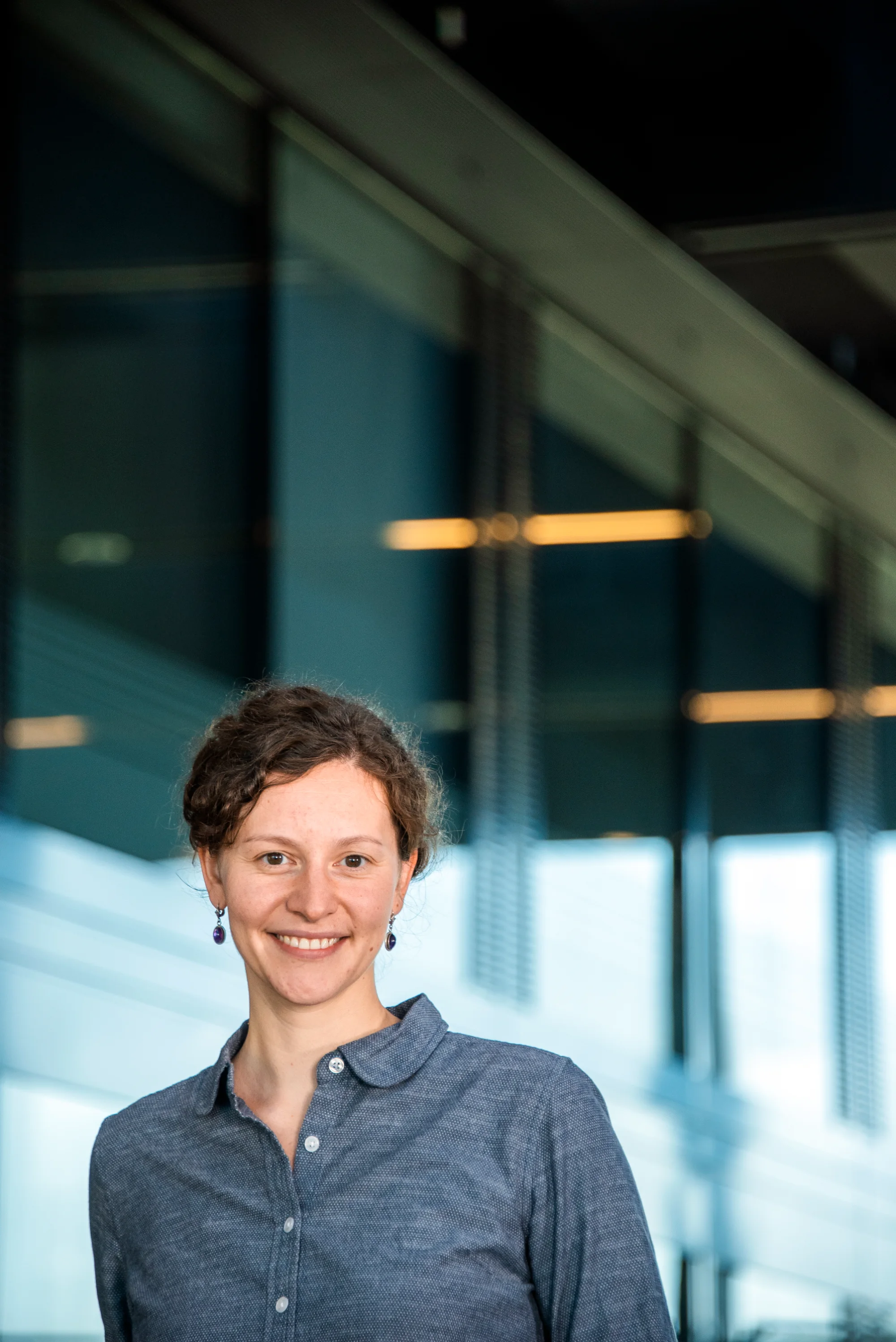 Employee with short hair, glass architecture behind — SWMH, employer branding photography by Janina Laszlo