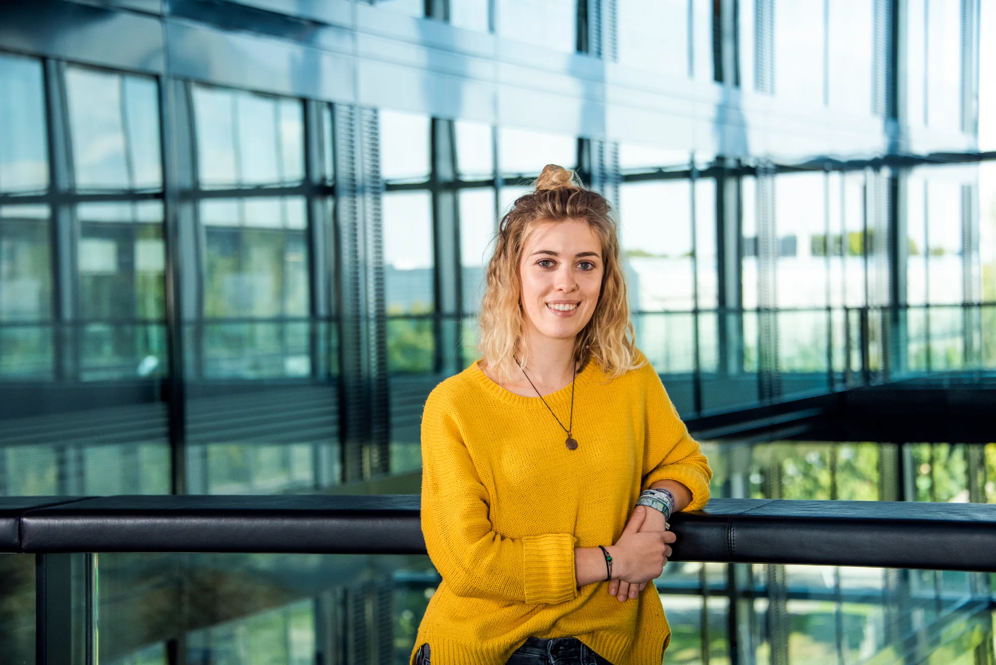 Employee in a yellow sweater on a gallery walkway — SWMH, employer branding photography by Janina Laszlo