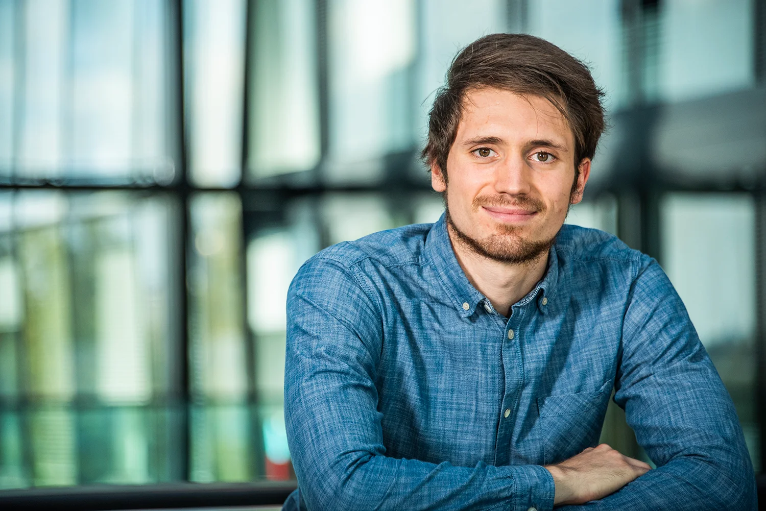 Employee in a denim shirt leaning on a railing — SWMH, employer branding photography by Janina Laszlo