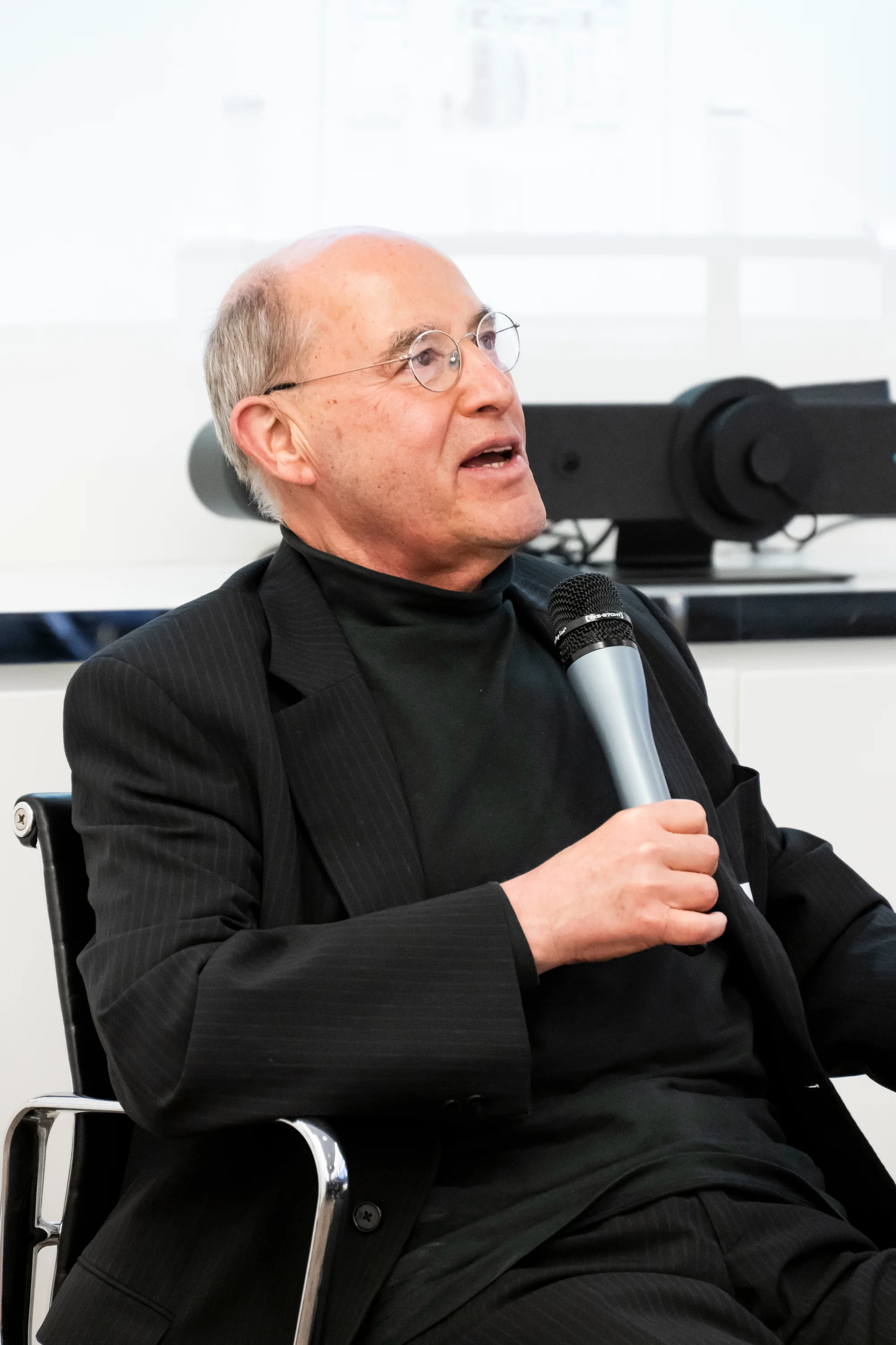 Gregor Gysi speaking into a microphone on stage — Taylor Wessing with Gregor Gysi, corporate event photography by Janina Laszlo, Munich