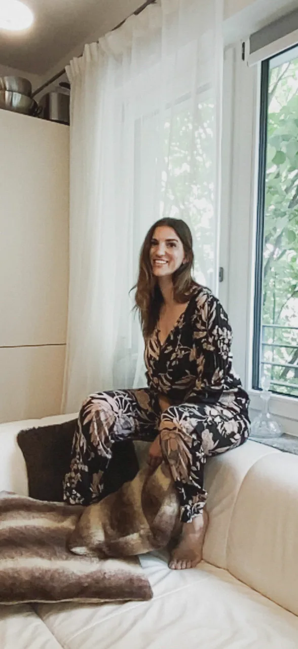 Soprano Aline Lettow smiling on a white sofa by a window, Berlin — Deutsche Telekom FaceTime Session, commercial and lifestyle photography by Janina Laszlo