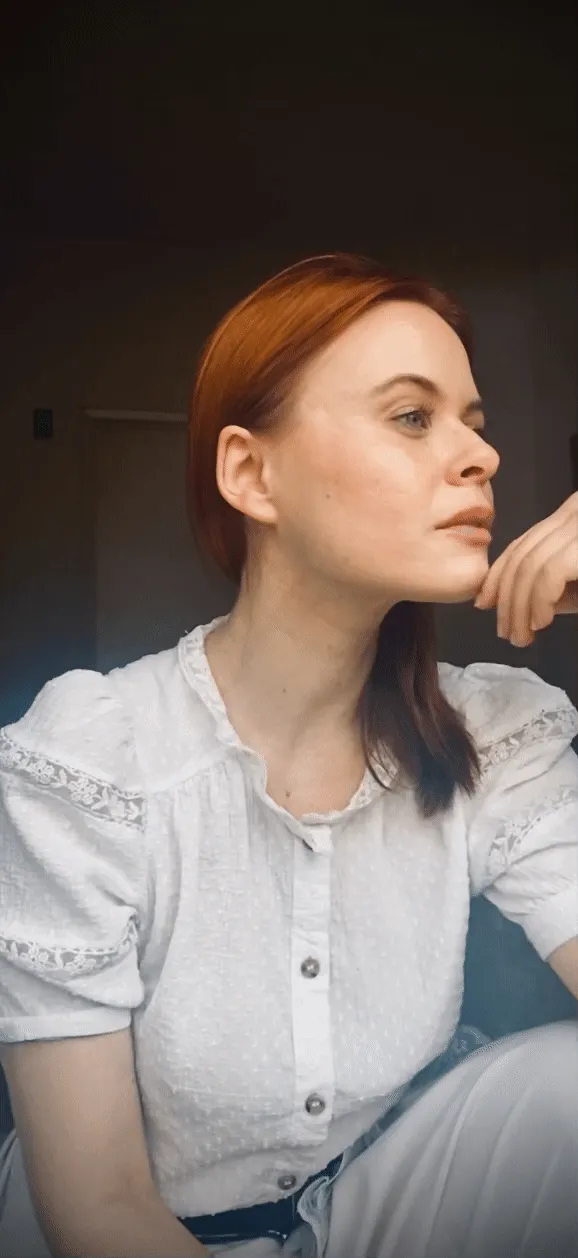 Actress Augie Duke with red hair and white lace blouse, resting her chin on her hand, Los Angeles — Deutsche Telekom FaceTime Session, commercial and lifestyle photography by Janina Laszlo