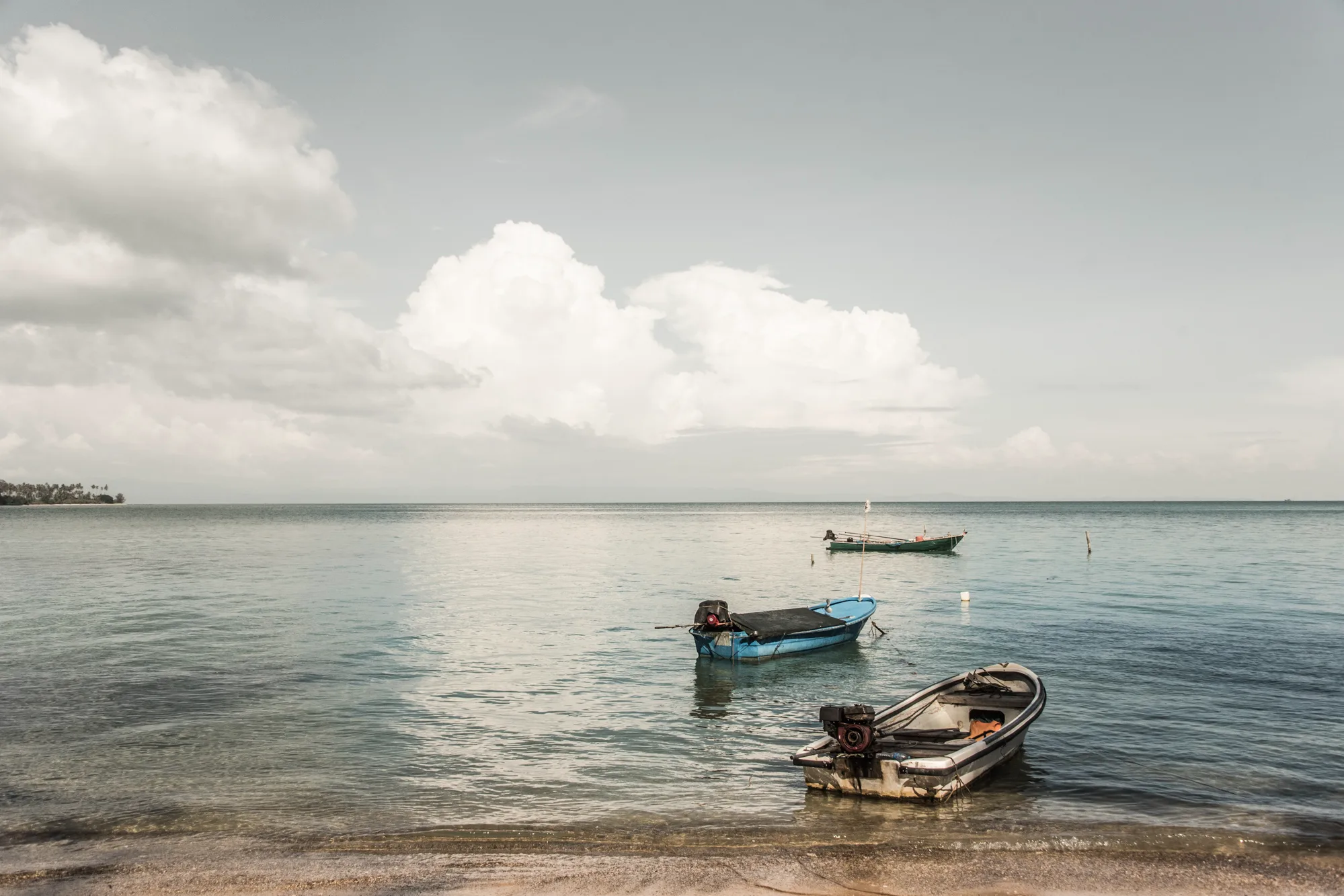 Small fishing boats moored in a calm turquoise bay, Trat islands — Thailand, travel and documentary photography by Janina Laszlo