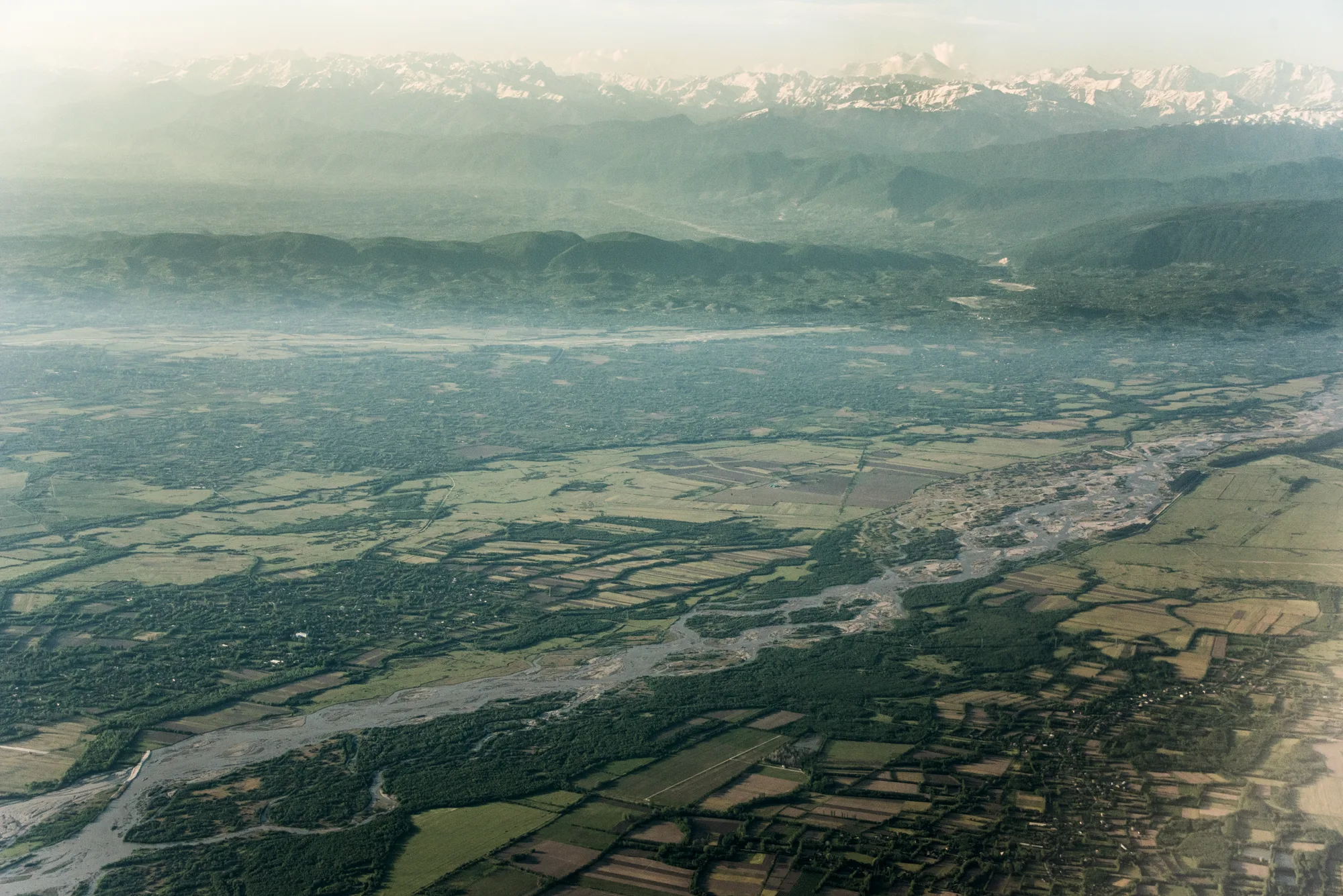 Aerial view of a braided river, fields and the snowy Caucasus range, Georgia — Travel Notes, travel photography by Janina Laszlo