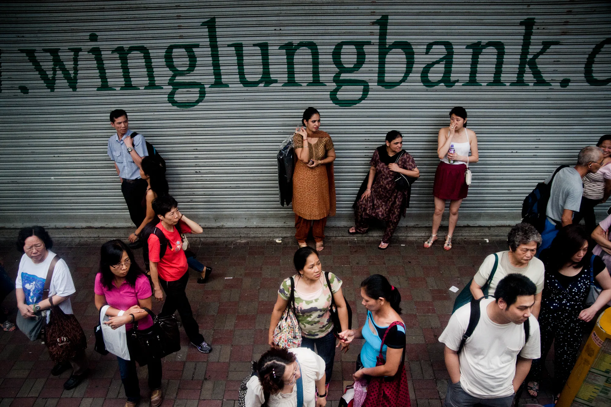 People waiting in front of a bank shutter seen from above, Hong Kong — Travel Notes, travel photography by Janina Laszlo